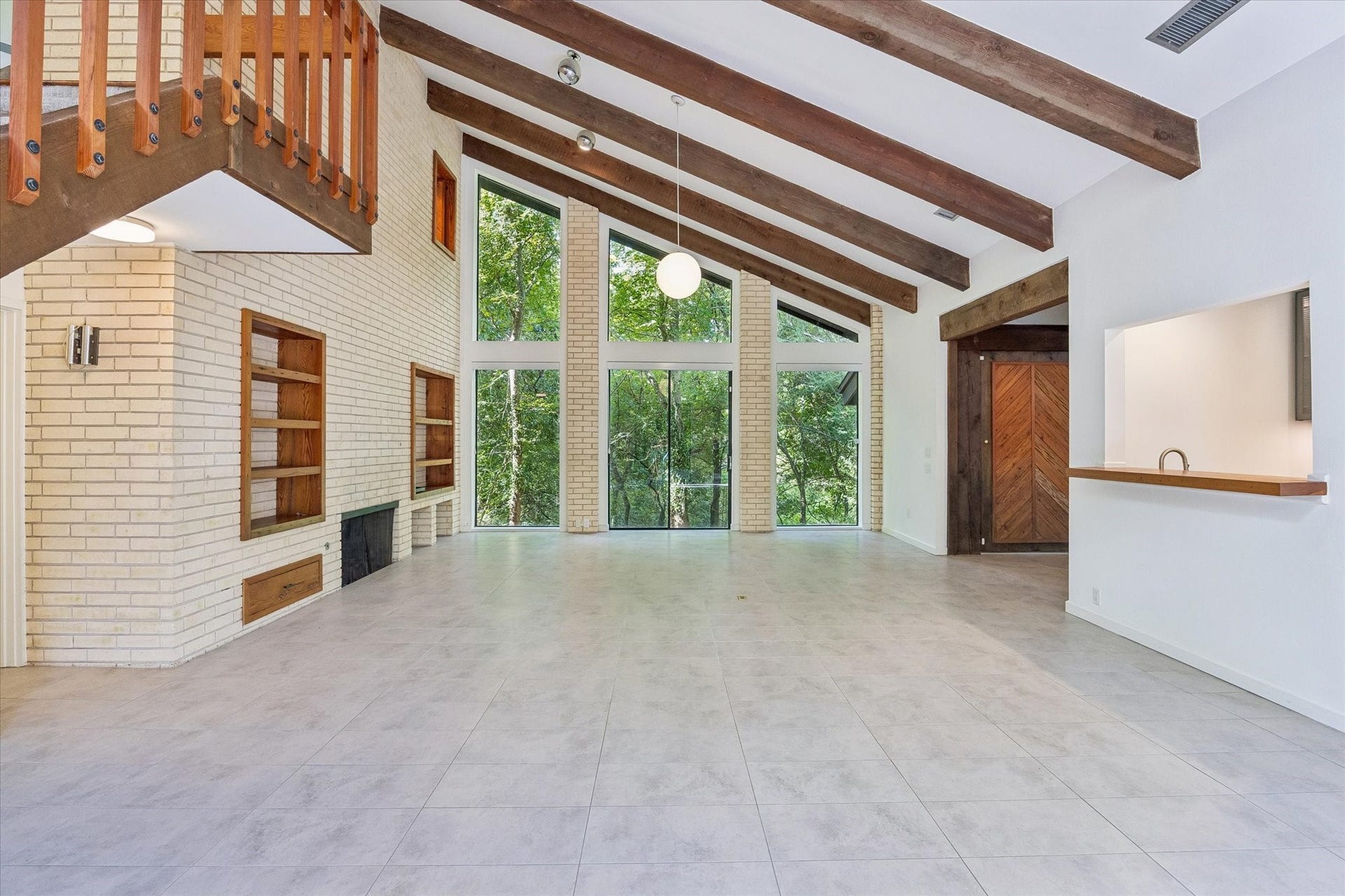 104 Gershwin Drive, Houston, TX 77079 Walls of windows and sliding glass doors bring the wooded surroundings into the living space, while the vaulted ceiling & exposed wood beams emphasize the rooms impressive scale.