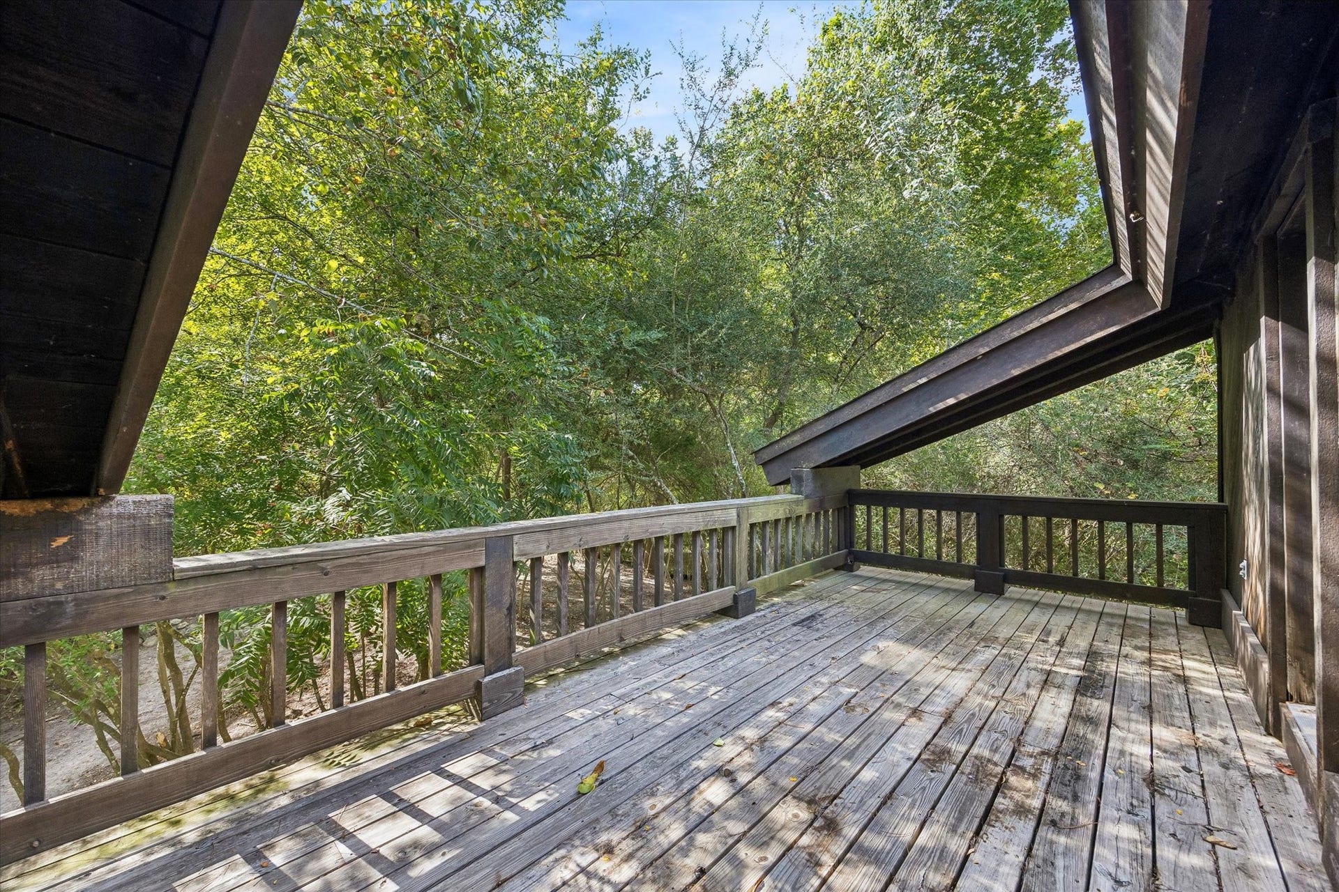 104 Gershwin Drive, Houston, TX 77079 Expansive wraparound porch accessed from both the 2nd-floor office & primary suite, offering a wonderful extension of the living space surrounded by mature trees & lush wooded views.