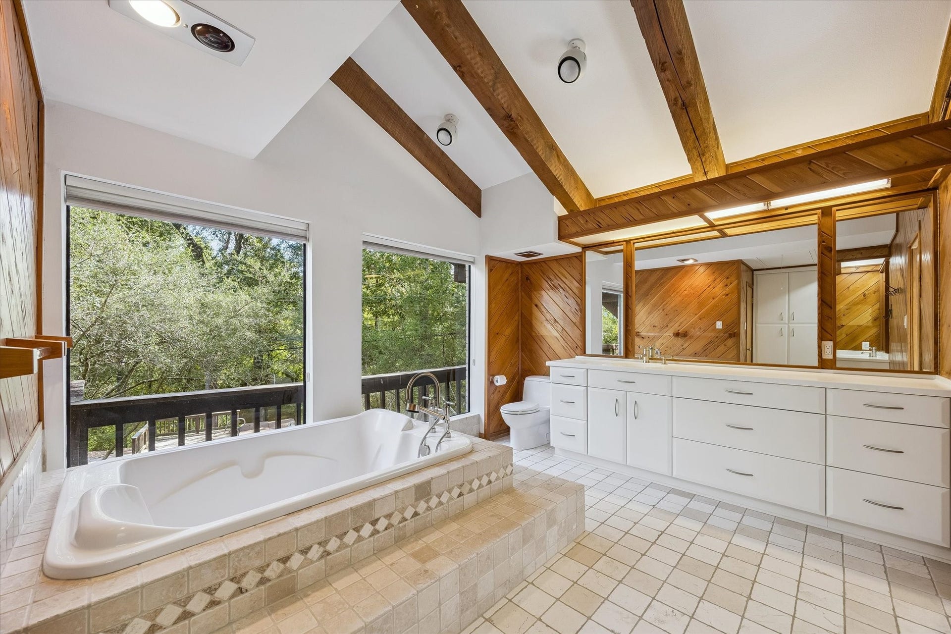 104 Gershwin Drive, Houston, TX 77079 Another view highlights the expansive vanity w/extensive cabinetry & counter space, oversized mirror & jetted tub, creating a spacious primary bath w/excellent storage.