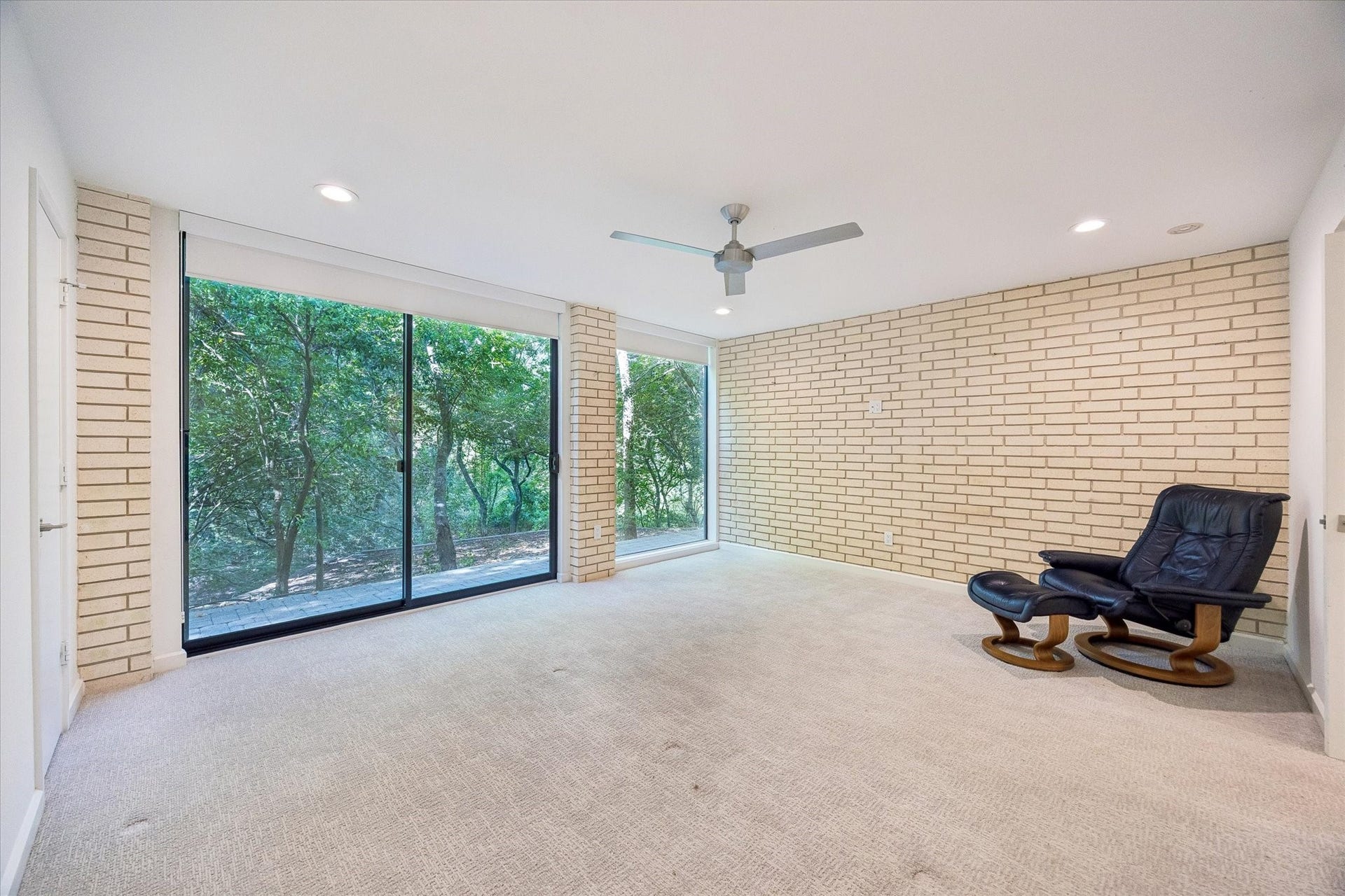 104 Gershwin Drive, Houston, TX 77079 Spacious secondary bedroom offers excellent flexibility as a guest room, home office or additional living space, w/sliding glass doors & expansive windows providing direct access to the outdoors.