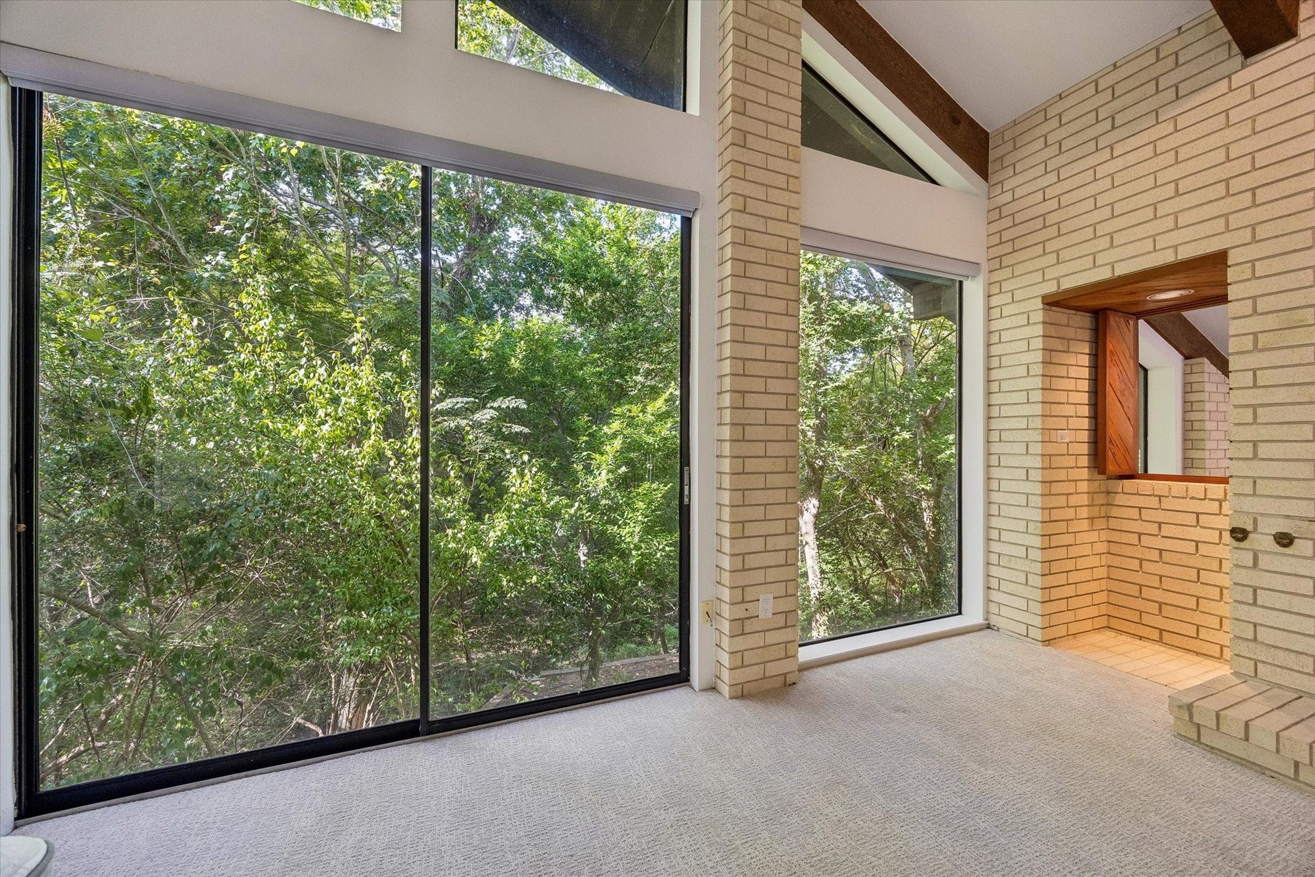 104 Gershwin Drive, Houston, TX 77079 Expansive windows surround the primary bedroom w/treetop views, while a unique interior cutout overlooks the living room below & enhances the homes open architectural design.