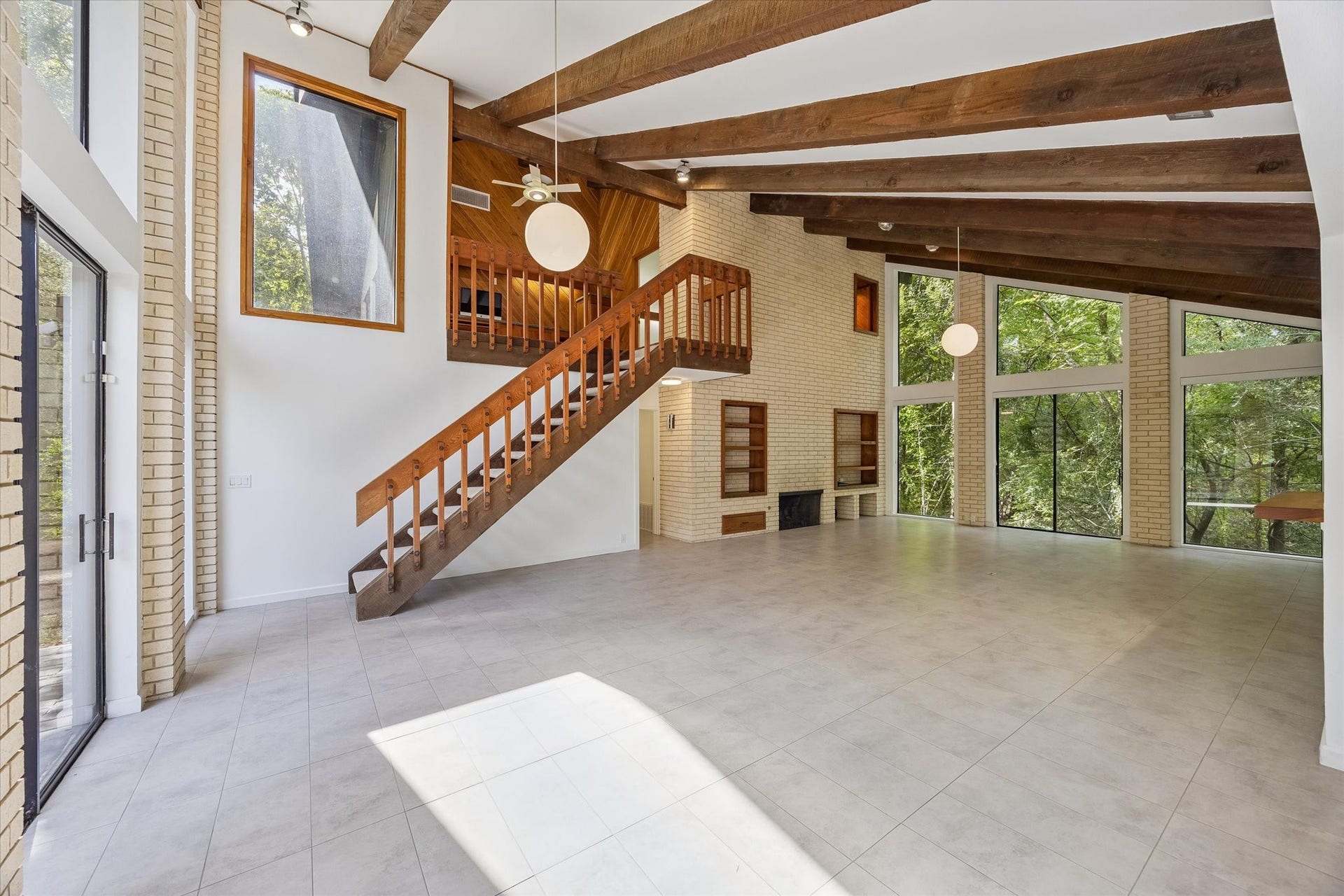 104 Gershwin Drive, Houston, TX 77079 Natural light fills the living room from multiple directions, highlighting the open staircase & creating a seamless connection between the main living area & upper level.