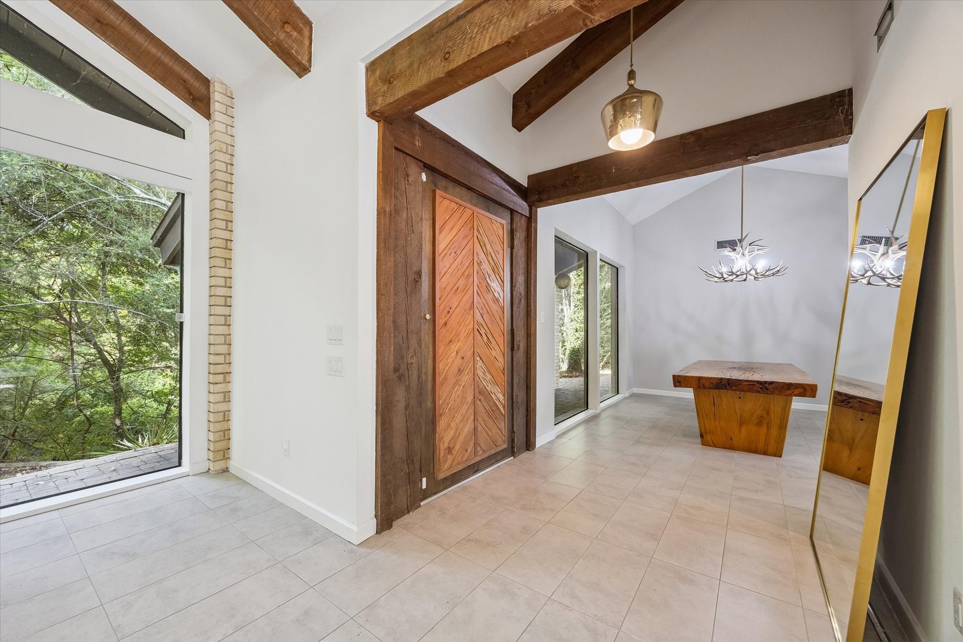 104 Gershwin Drive, Houston, TX 77079 Striking front entrance showcases the oversized cypress wood door framed by rich wood beams, soaring ceilings & expansive windows, opening directly to the dining and living rooms.