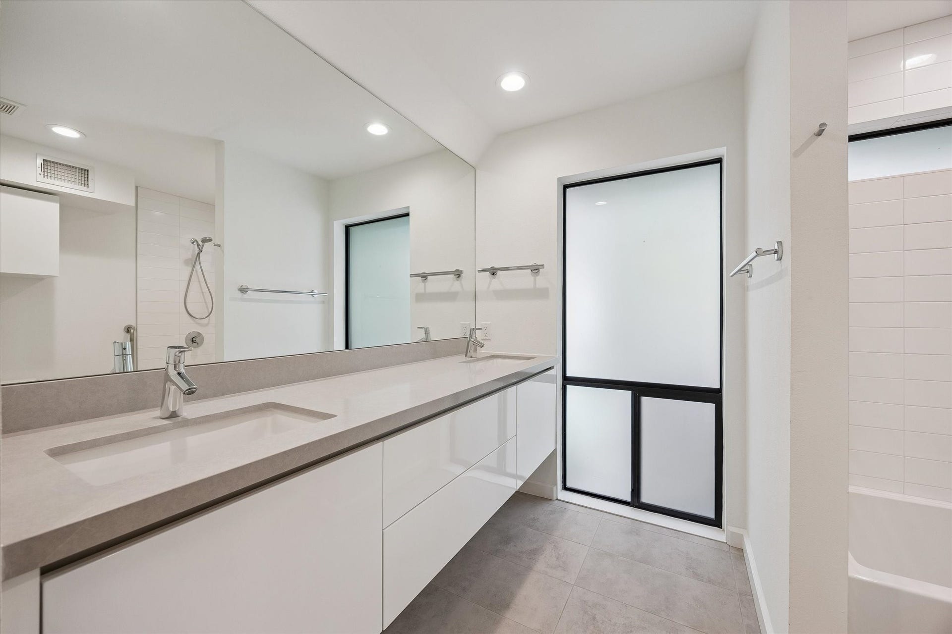 104 Gershwin Drive, Houston, TX 77079 Beautifully updated secondary bath features a sleek double vanity w/expansive countertop, excellent storage, oversized mirror, modern fixtures & a tub/shower combination.