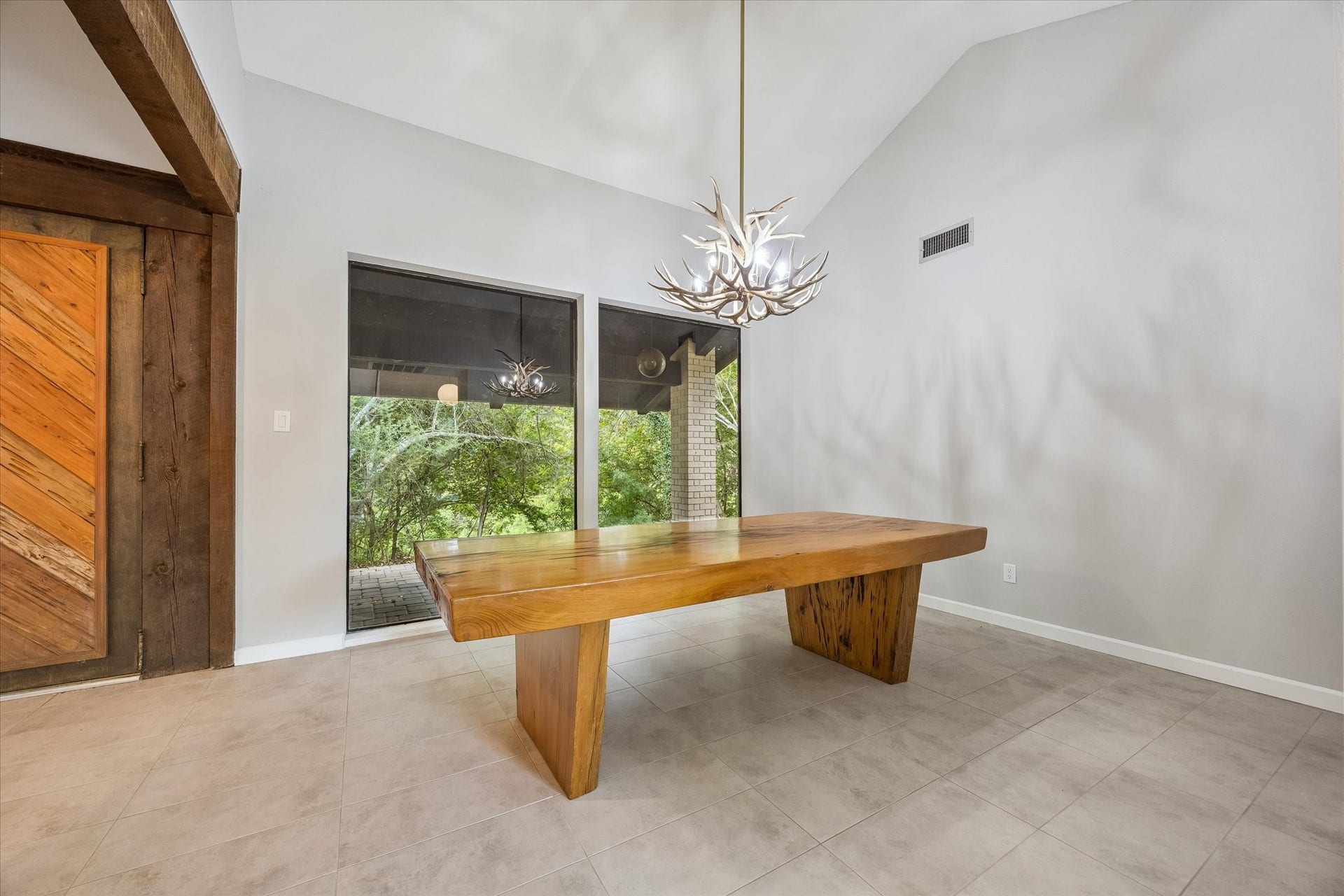 104 Gershwin Drive, Houston, TX 77079 From this angle, the dining room highlights its open feel & connection to the outdoors, w/beautiful natural light, wooded views & warm wood accents at the entry.