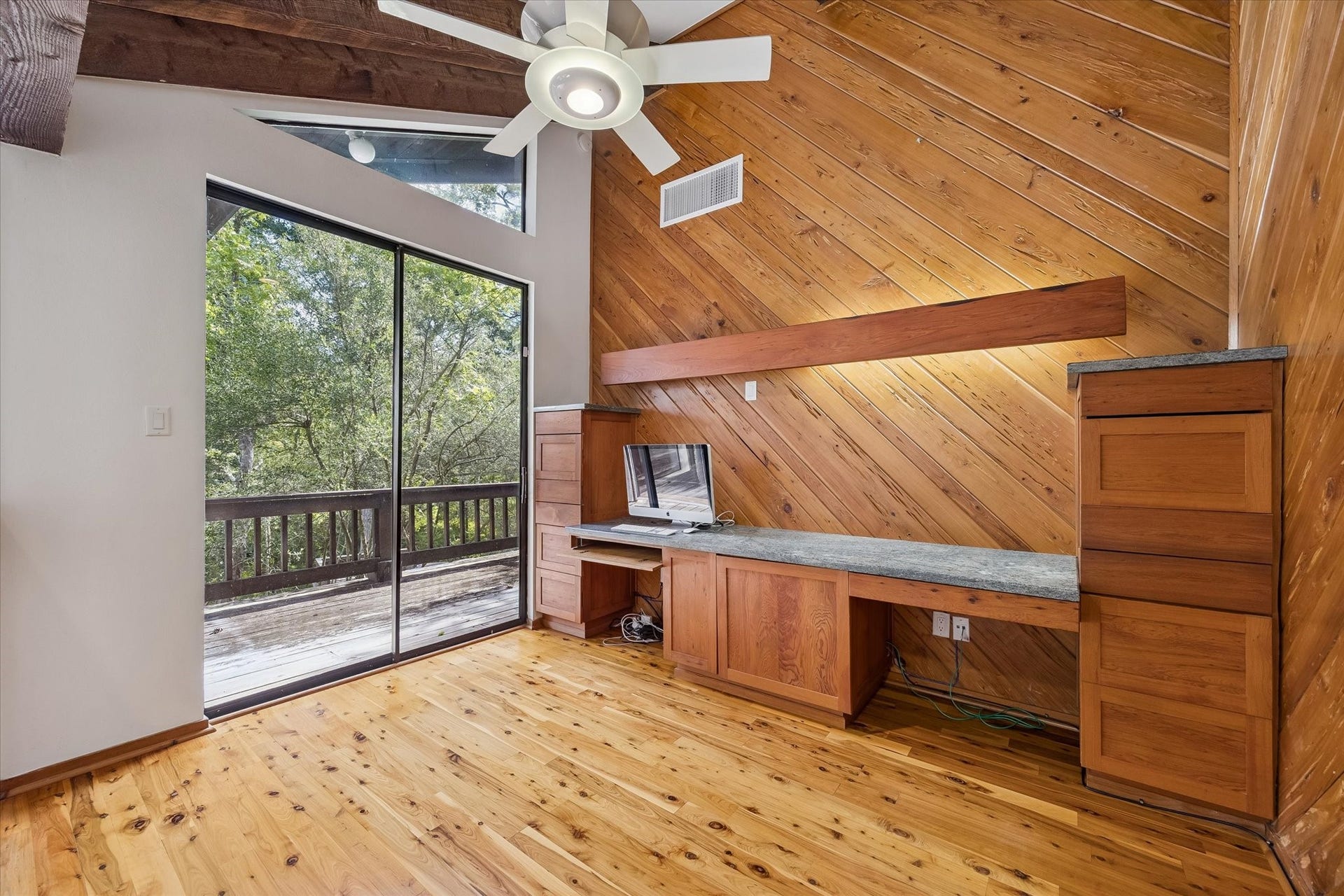 104 Gershwin Drive, Houston, TX 77079 Inviting 2nd-floor office near the primary suite showcases beautiful Pecky Cypress wood, built-in cabinetry & workspace, vaulted ceiling & sliding glass doors opening to the wraparound porch.