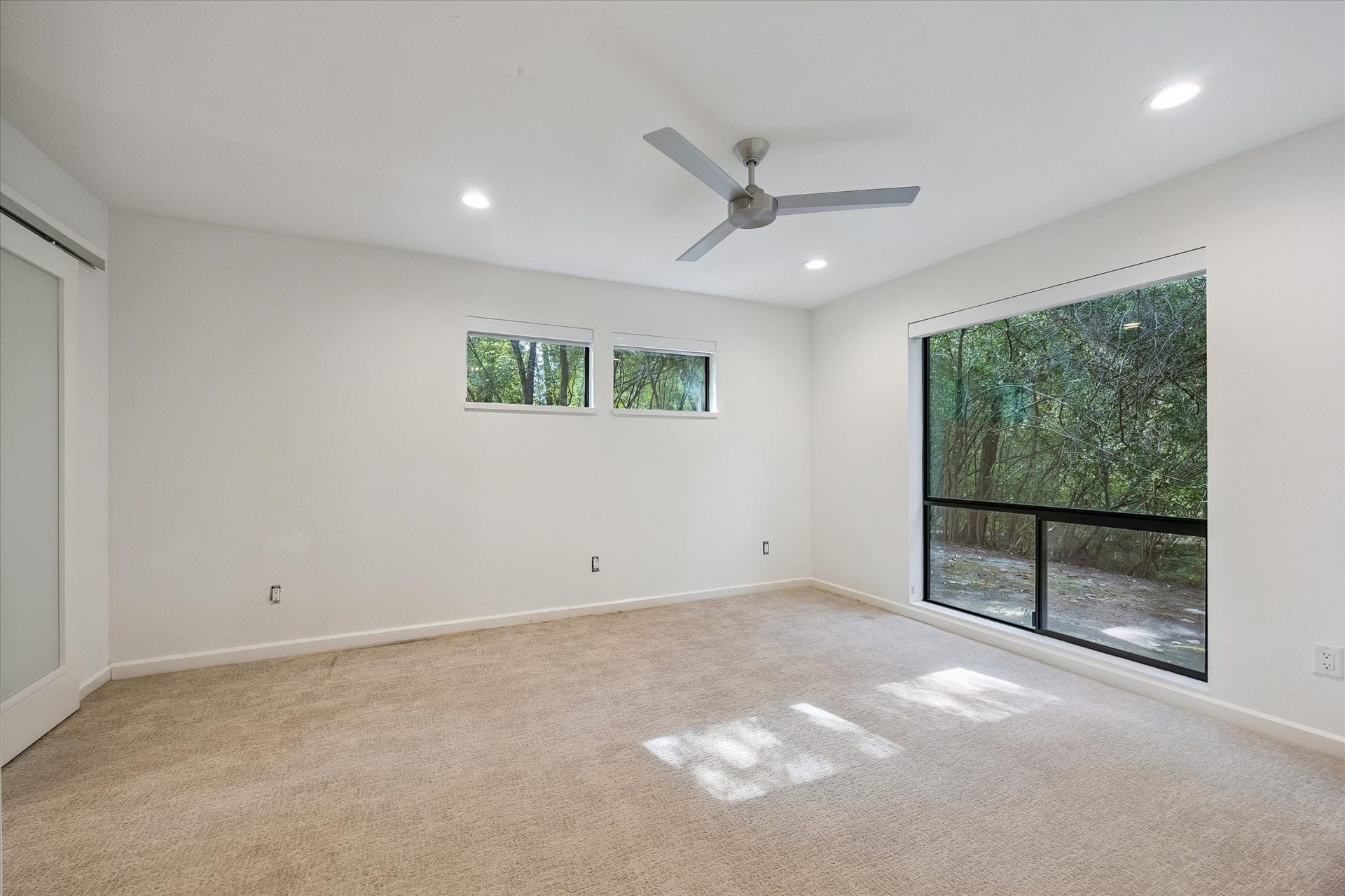 104 Gershwin Drive, Houston, TX 77079 Light-filled secondary bedroom features multiple windows, a ceiling fan & an ensuite bath.