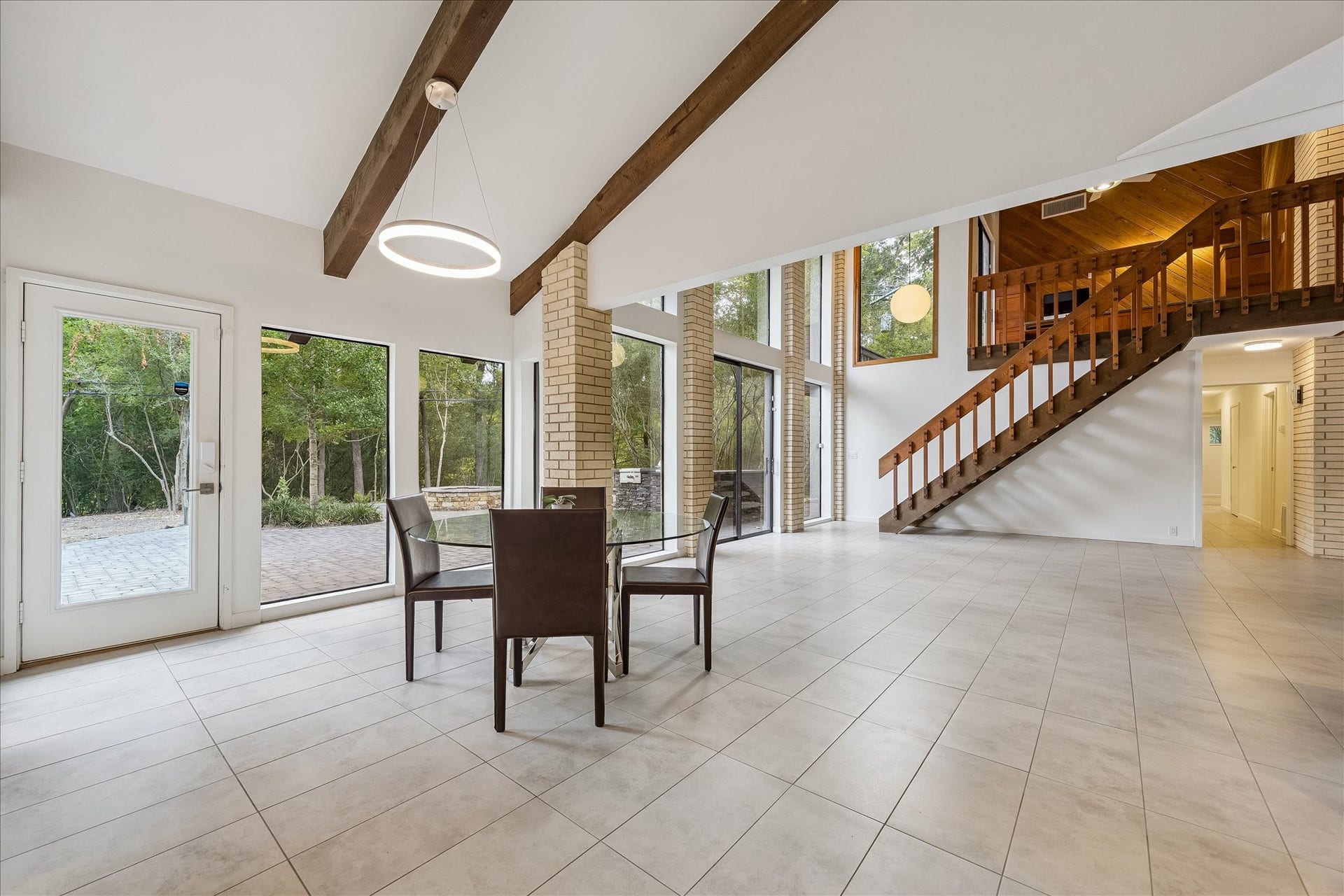 104 Gershwin Drive, Houston, TX 77079 Breakfast area features a contemporary circular light fixture & flows seamlessly into the expansive living area, creating an open layout ideal for everyday living & entertaining.