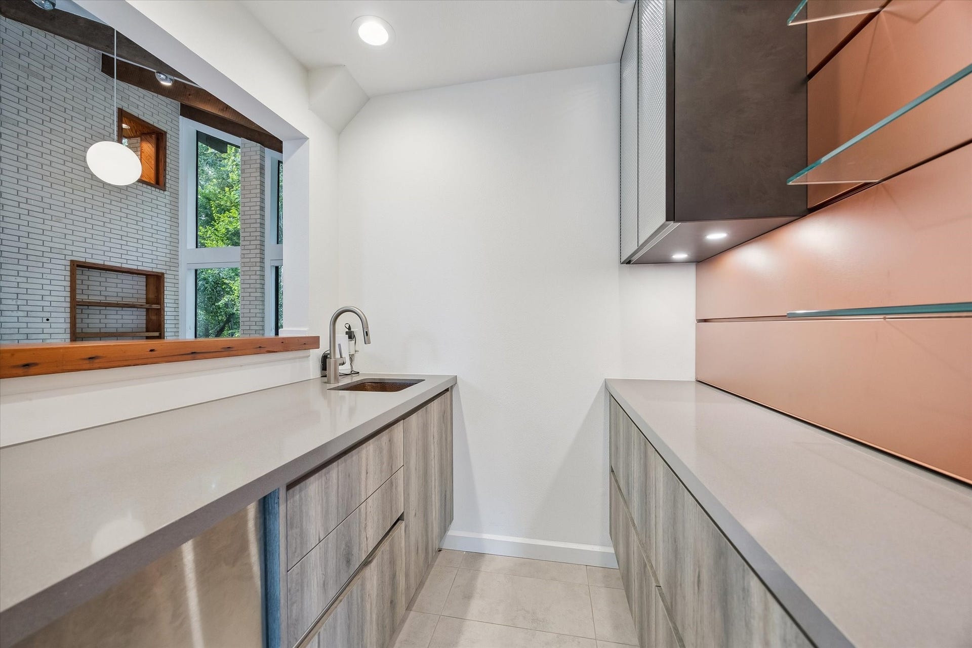 104 Gershwin Drive, Houston, TX 77079 Closer view of the bar showcases sleek cabinetry, quartz counters, sink, glass display shelving & under-cabinet lighting, all conveniently positioned just off the main living area.