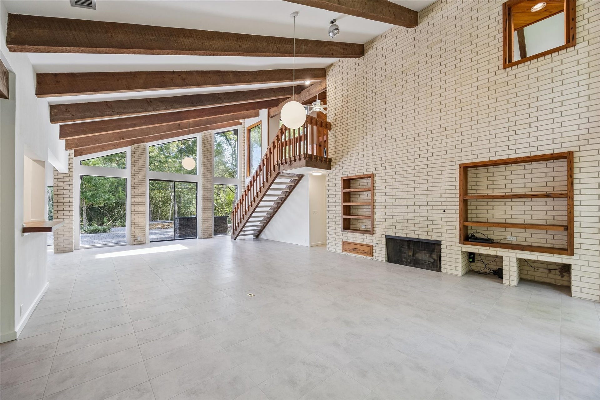 104 Gershwin Drive, Houston, TX 77079 The brick fireplace anchors the living room, complemented by built-in shelving & expansive floor space offering plenty of flexibility for multiple seating areas.