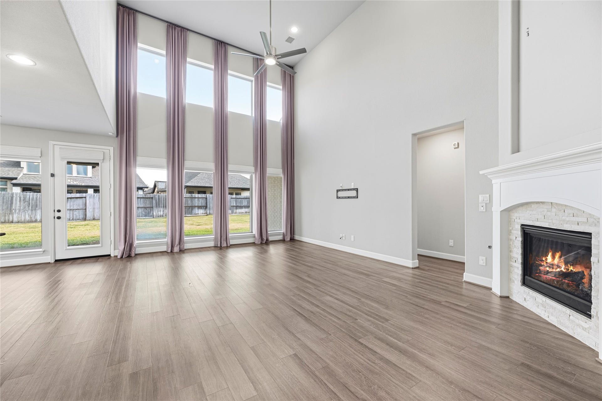 9511 Shaded Tree Drive, Missouri City, TX 77459 Grand living room with soaring ceilings, upgraded fireplace, sleek floors and neutral paint.