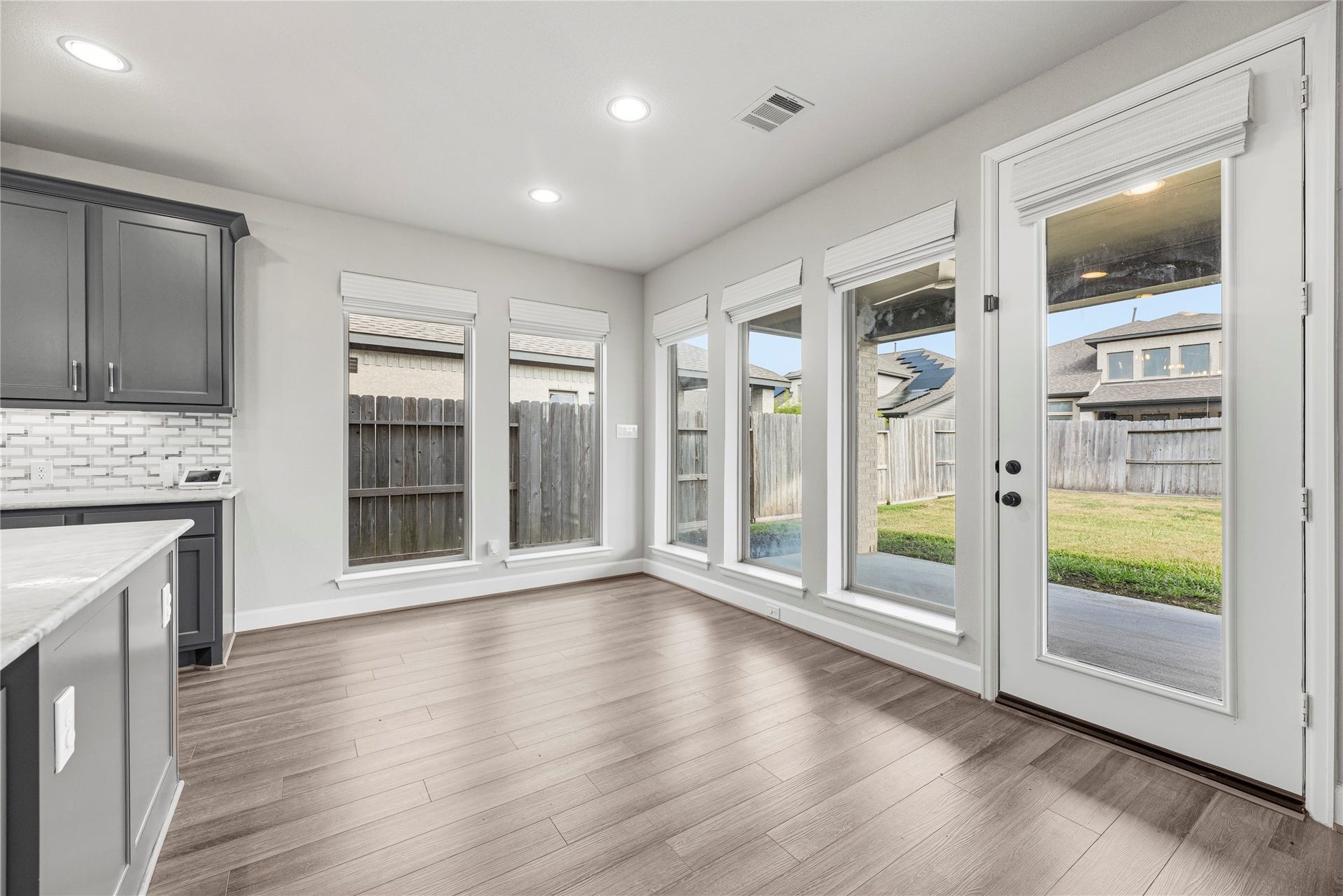 9511 Shaded Tree Drive, Missouri City, TX 77459 Breakfast room opening from the kitchen, surrounded by windows and with recessed lights.