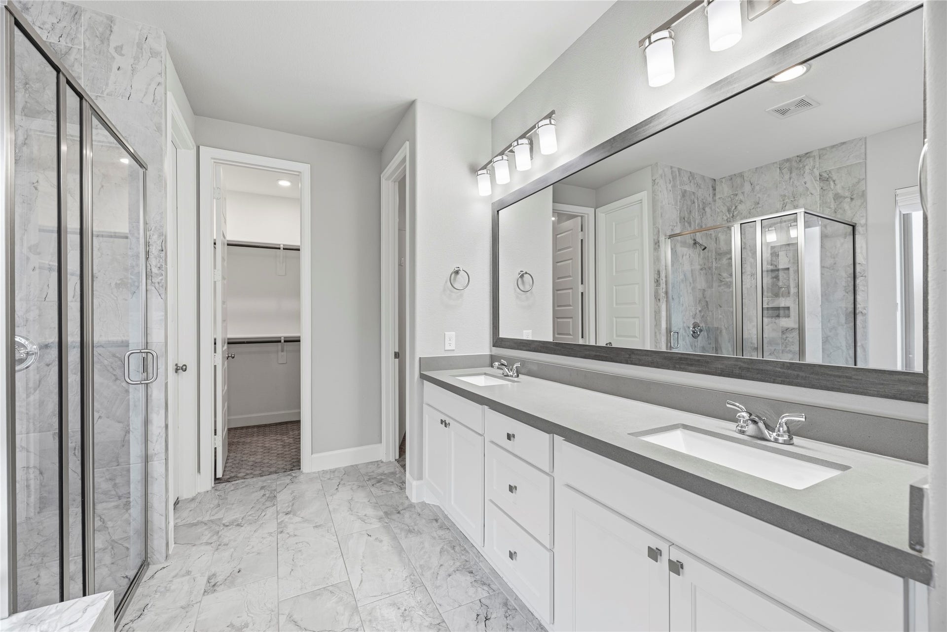 9511 Shaded Tree Drive, Missouri City, TX 77459 Primary en-suite with a double sink vanity, framed mirror, large walk-in shower and soaking tub.