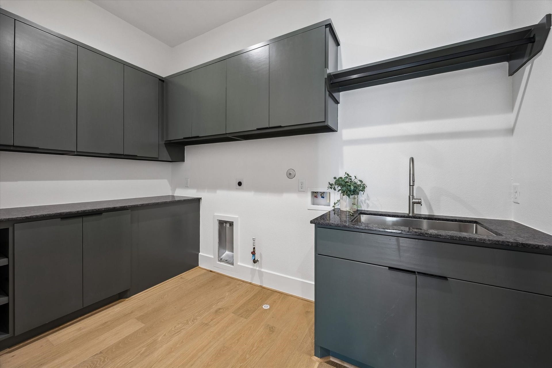 335 Harvard Street, Houston, TX 77007 Designed with everyday organization in mind, the utility room pairs extensive cabinetry with generous counter space, a utility sink and dedicated hanging space.