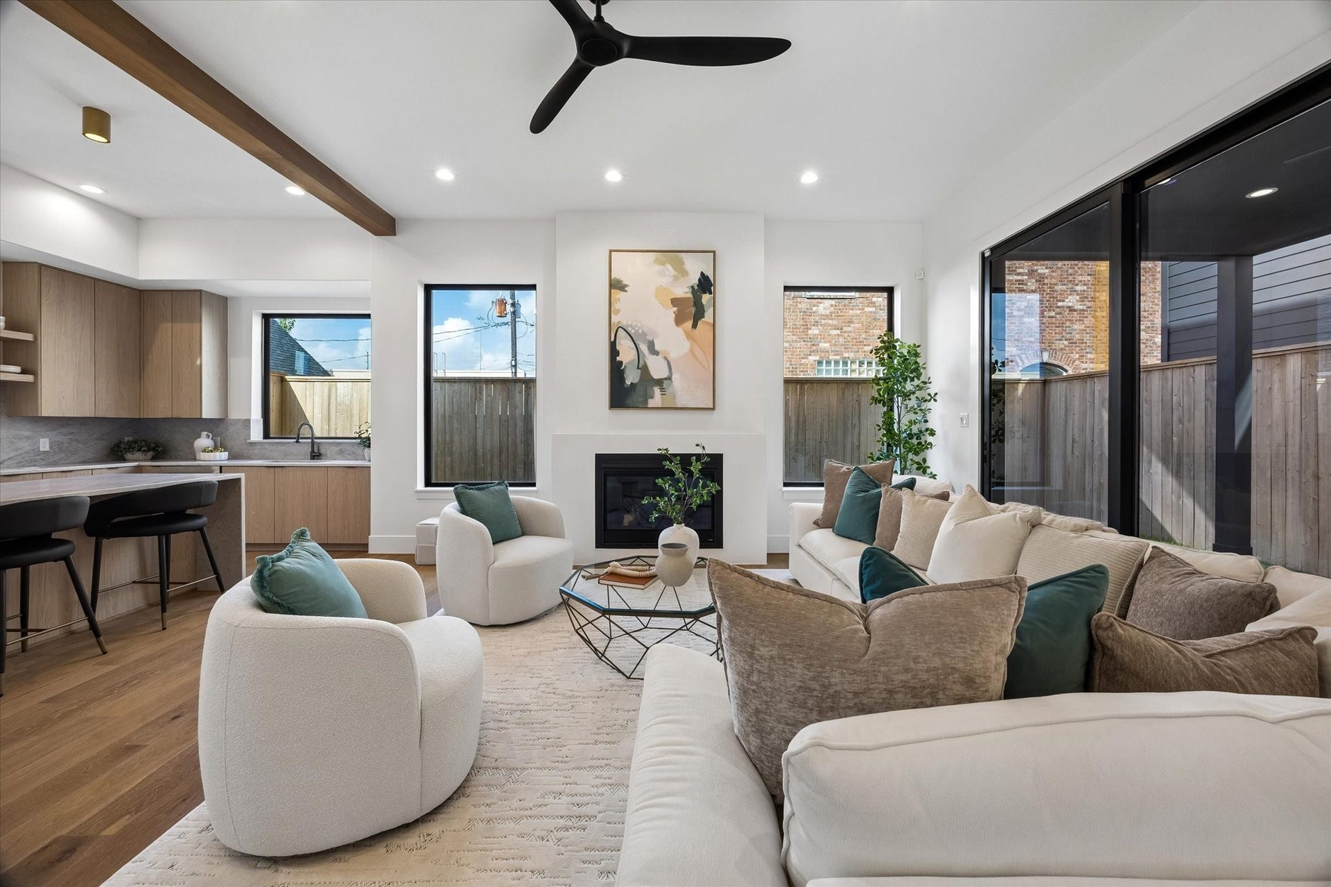 335 Harvard Street, Houston, TX 77007 Framed by tall windows, the fireplace anchors the living room while expansive glass doors bring the covered outdoor space directly into view. Its generous proportions leave plenty of room for conversation, entertaining and everyday gathering.