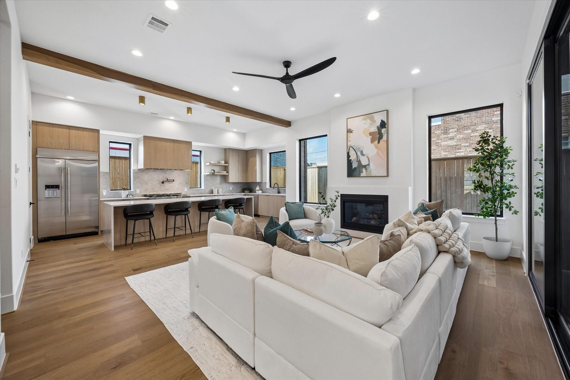 335 Harvard Street, Houston, TX 77007 From this angle, the connection between the living room and kitchen takes center stage, with the oversized island creating a natural gathering point between the two. A warm wood ceiling beam subtly defines the kitchen while preserving the openness of the space.