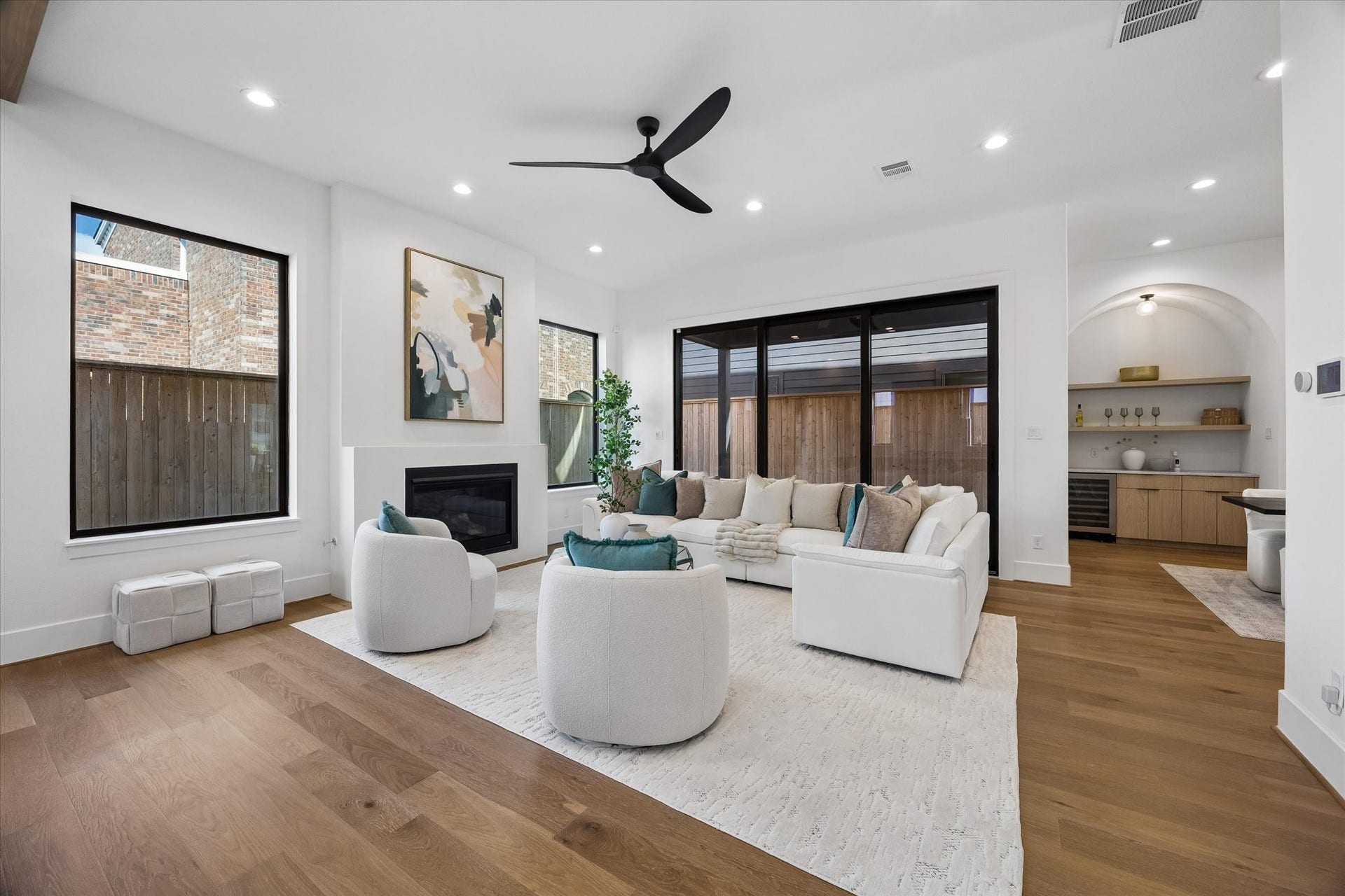 335 Harvard Street, Houston, TX 77007 Soaring ceilings and oversized windows give the living room a bright, expansive feel, while the sleek fireplace adds a clean focal point. Large sliding glass doors create a strong indoor outdoor connection and extend everyday living toward the covered patio.
