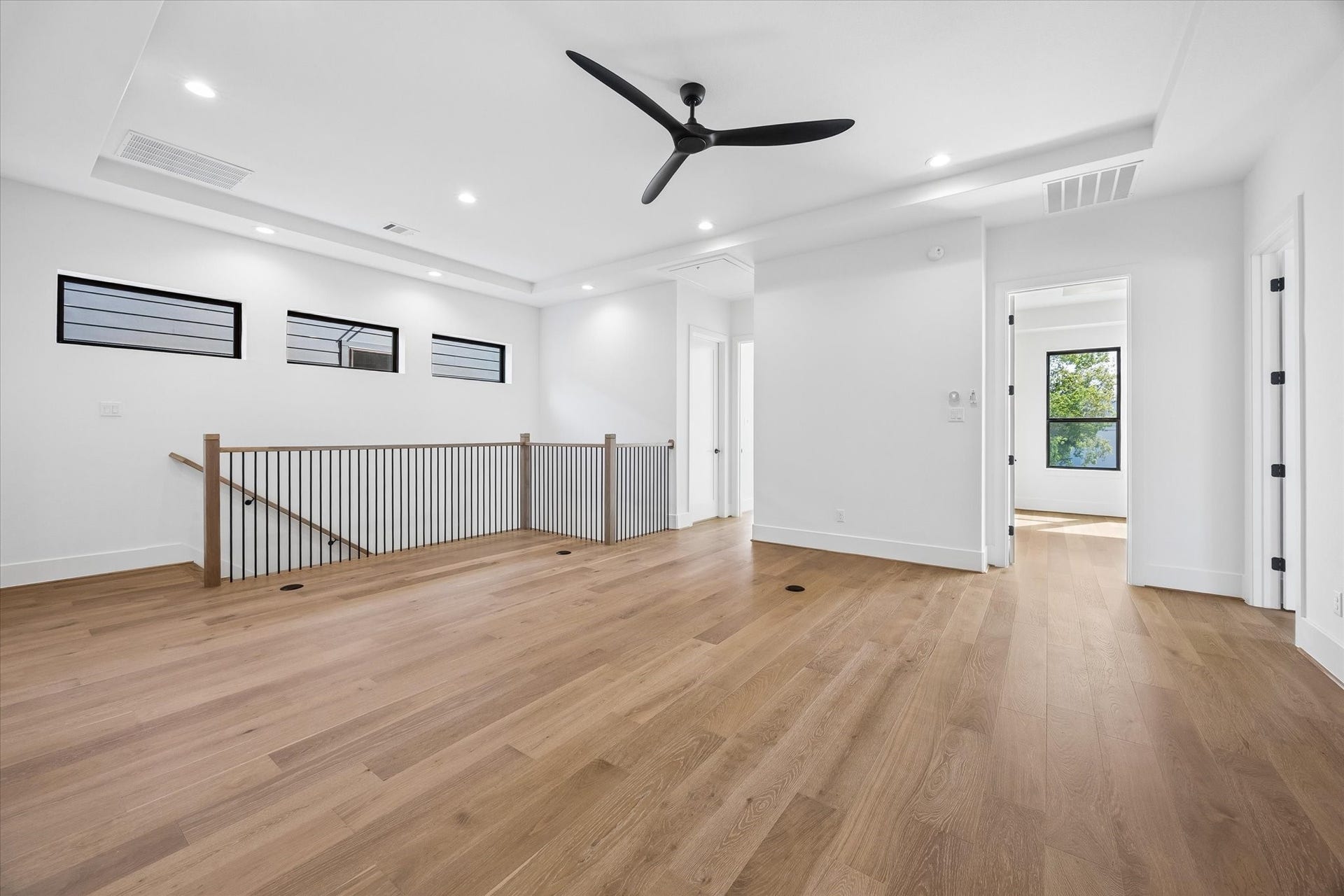 335 Harvard Street, Houston, TX 77007 Another view of the upstairs highlights its generous scale, tray ceiling and continuation of hardwood flooring. High set windows bring in natural light while maintaining privacy.