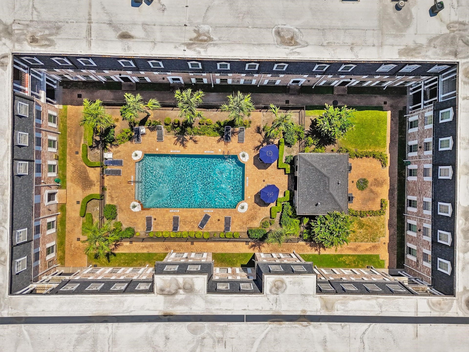 355 N Post Oak Lane, #839, Houston, TX 77024 Enjoy this stunning aerial view of a beautifully designed courtyard featuring a sparkling swimming pool, lush landscaping, and relaxing lounge areas, all surrounded by elegant architecture.