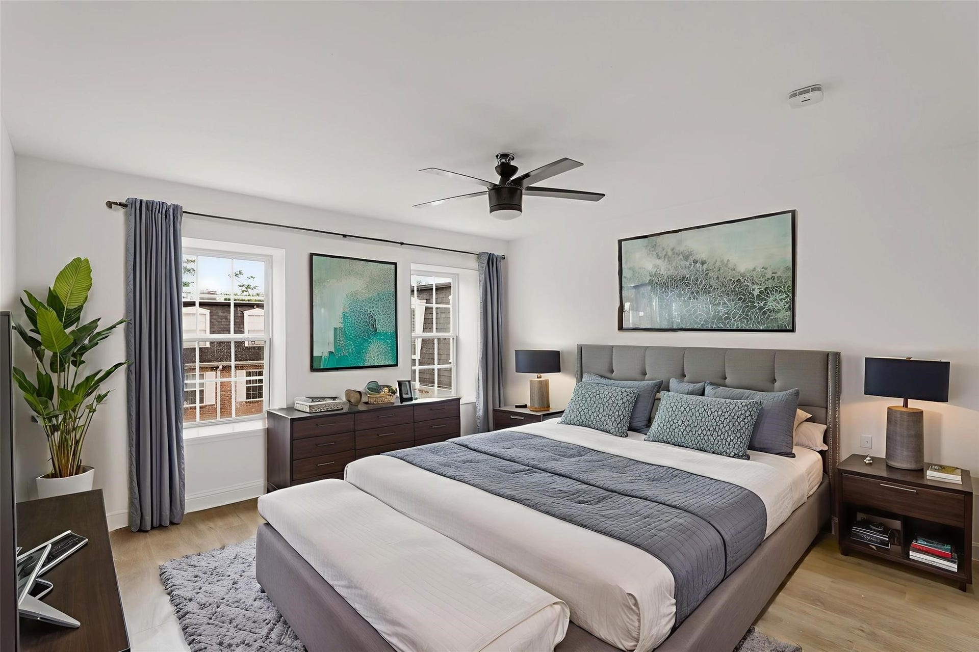355 N Post Oak Lane, #839, Houston, TX 77024 Spacious bedroom with a modern design, featuring a plush bed, stylish artwork, and ample natural light from large windows.