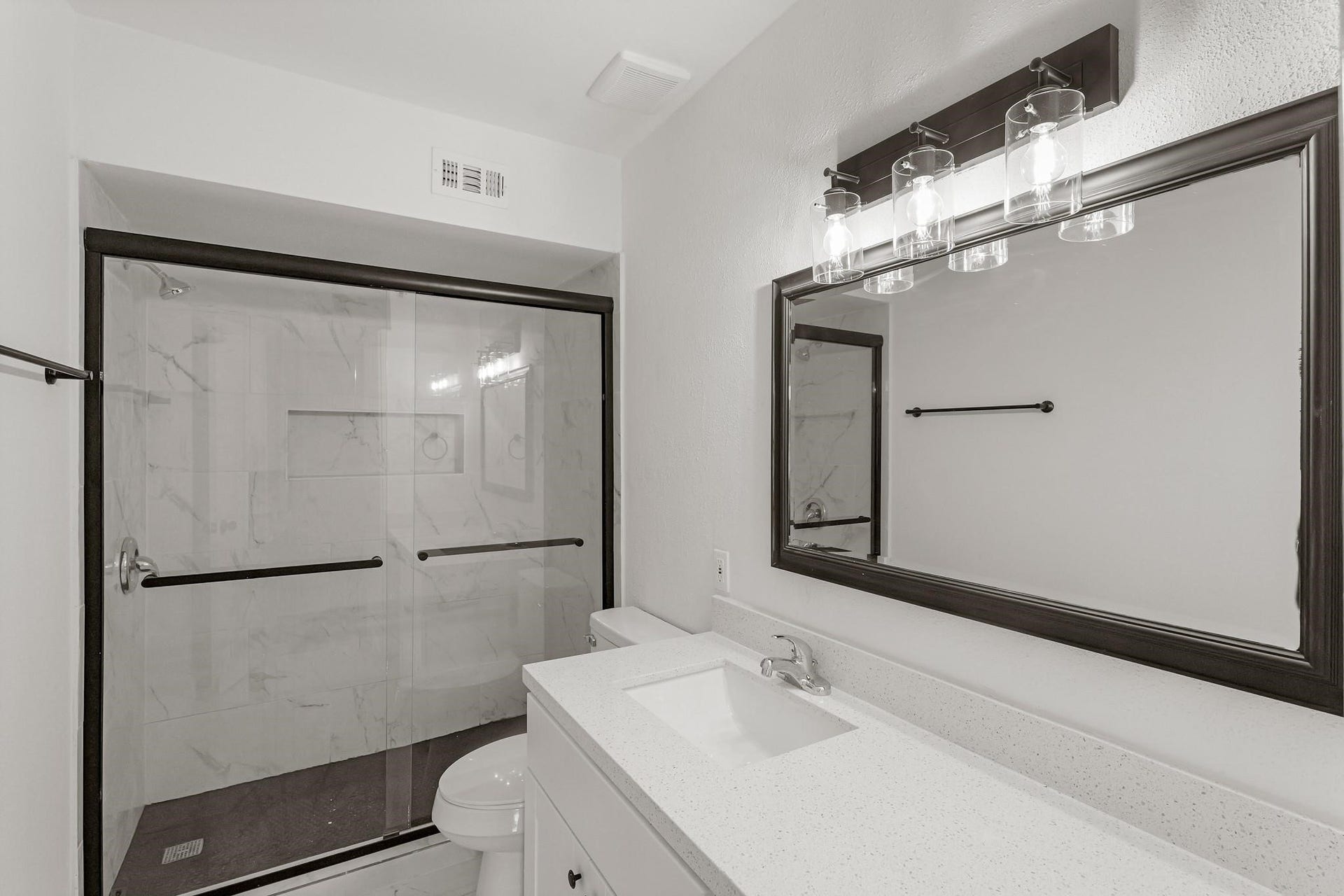 355 N Post Oak Lane, #839, Houston, TX 77024 Modern bathroom featuring a sleek glass-enclosed shower with marble-style tiles and a contemporary vanity with a large mirror and stylish lighting.