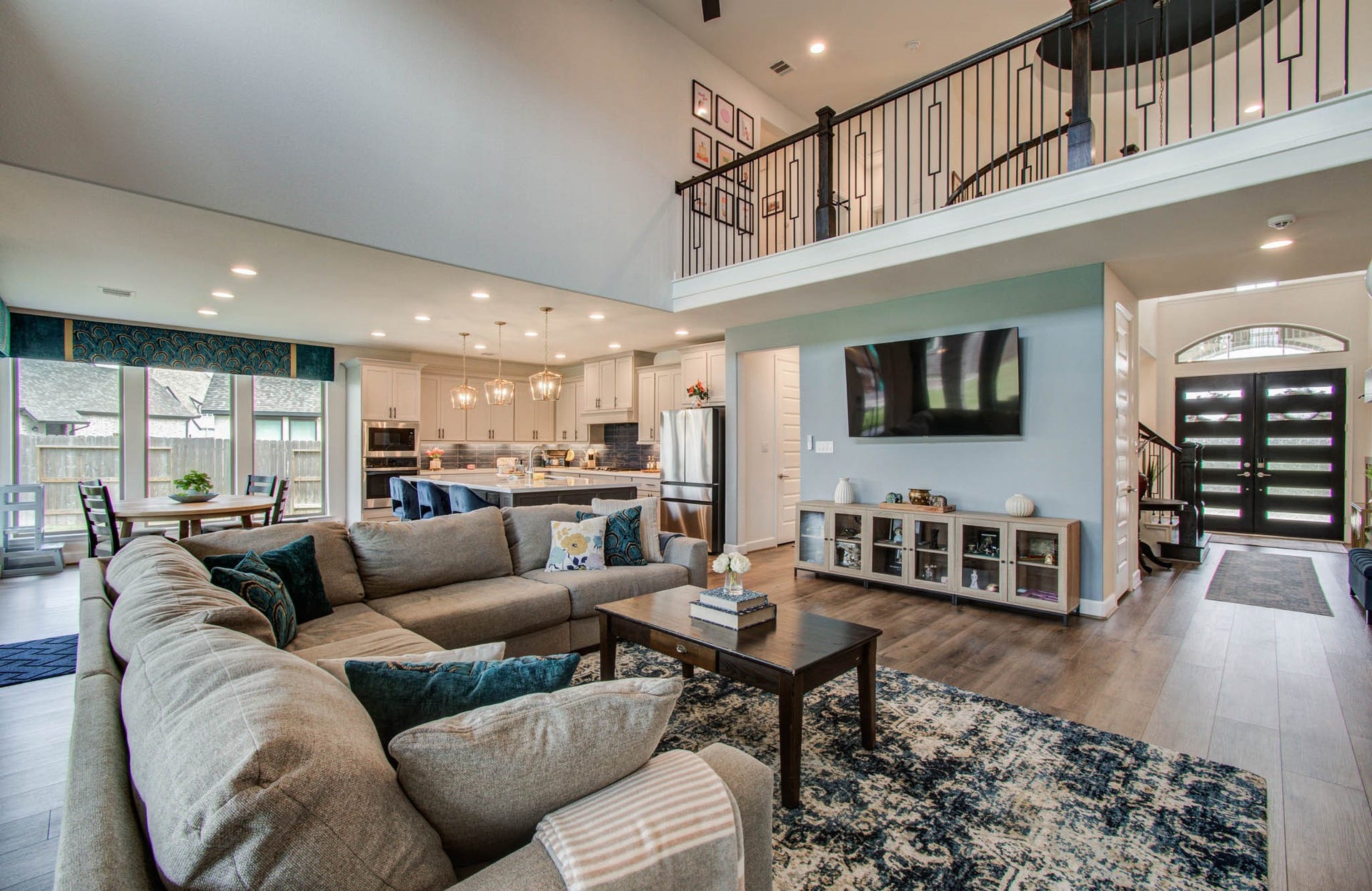 24430 Switchgrass Valley Way, Katy, TX 77493 Experience open-concept living with a spacious living room featuring an eye-level TV mount, seamlessly flowing into a modern kitchen and dining area, perfect for entertaining and relaxation.