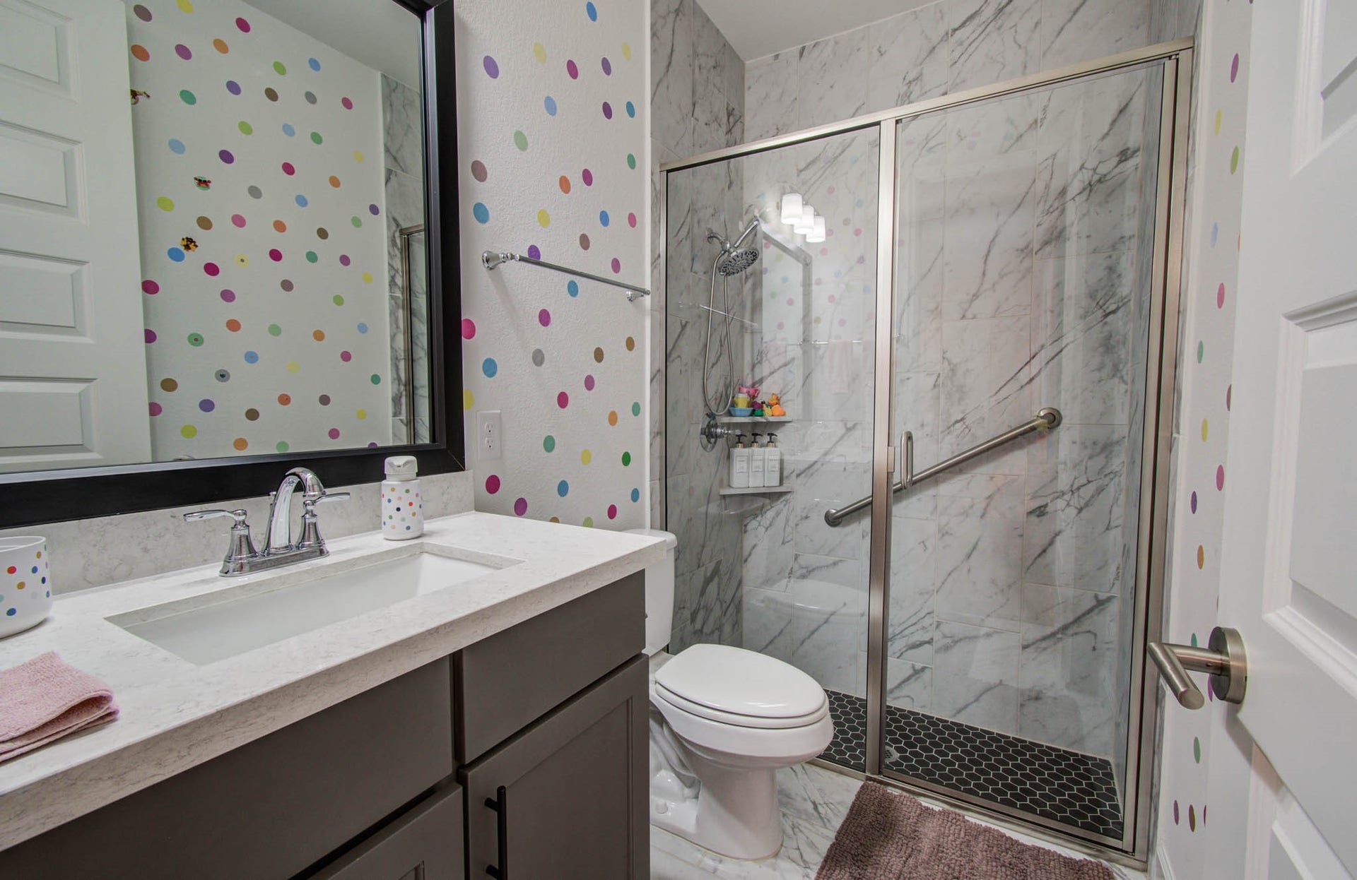 24430 Switchgrass Valley Way, Katy, TX 77493 Bright and cheerful, this secondary bathroom boasts a stylish glass-enclosed shower with elegant marble tiles, perfect for guests or family members.