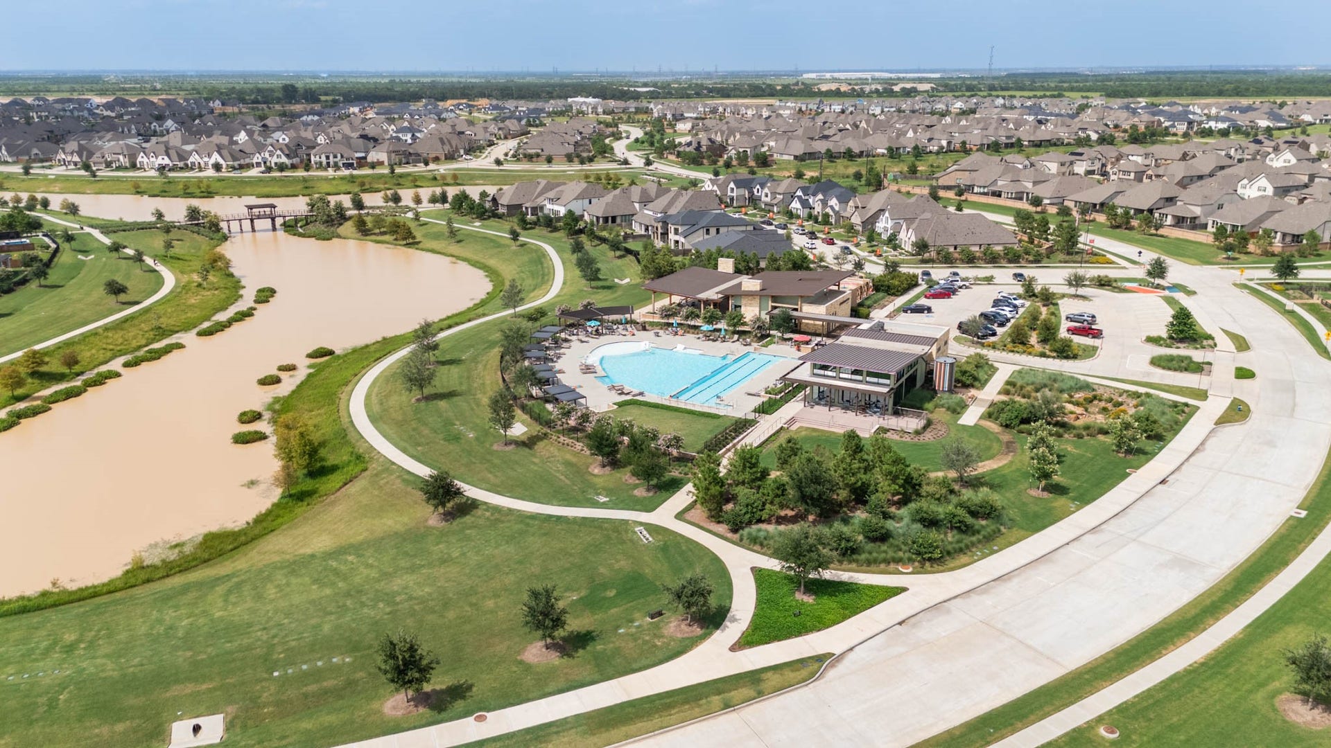 24430 Switchgrass Valley Way, Katy, TX 77493 Experience modern suburban living in this serene, family-friendly community featuring a central recreational area with a large swimming pool, inviting clubhouse, and a scenic pond surrounded by lush, landscaped greenery.