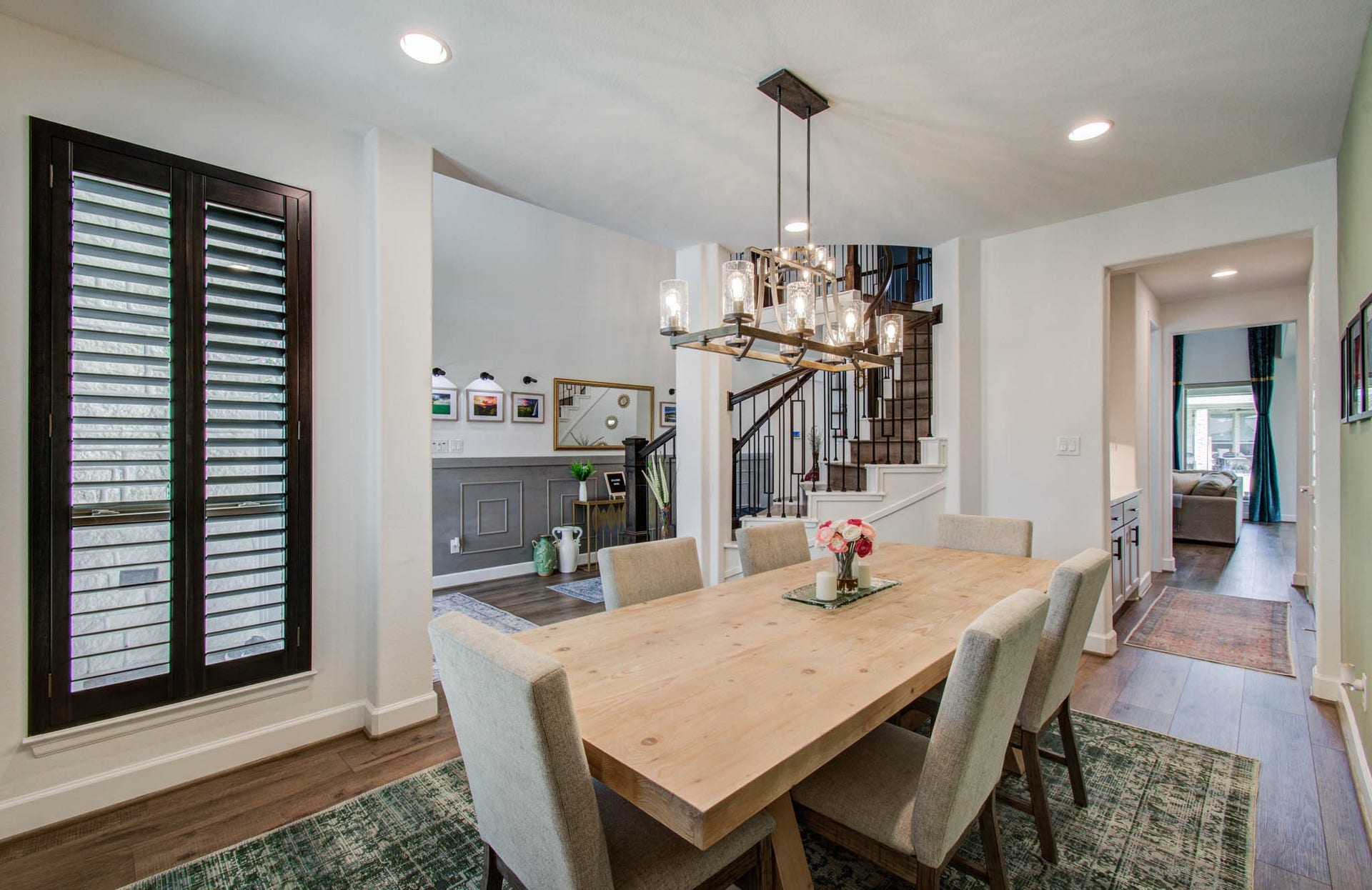 24430 Switchgrass Valley Way, Katy, TX 77493 Elegant custom shutters grace the front of this inviting home, complementing the open dining area and stylish staircase for a perfect blend of charm and sophistication.