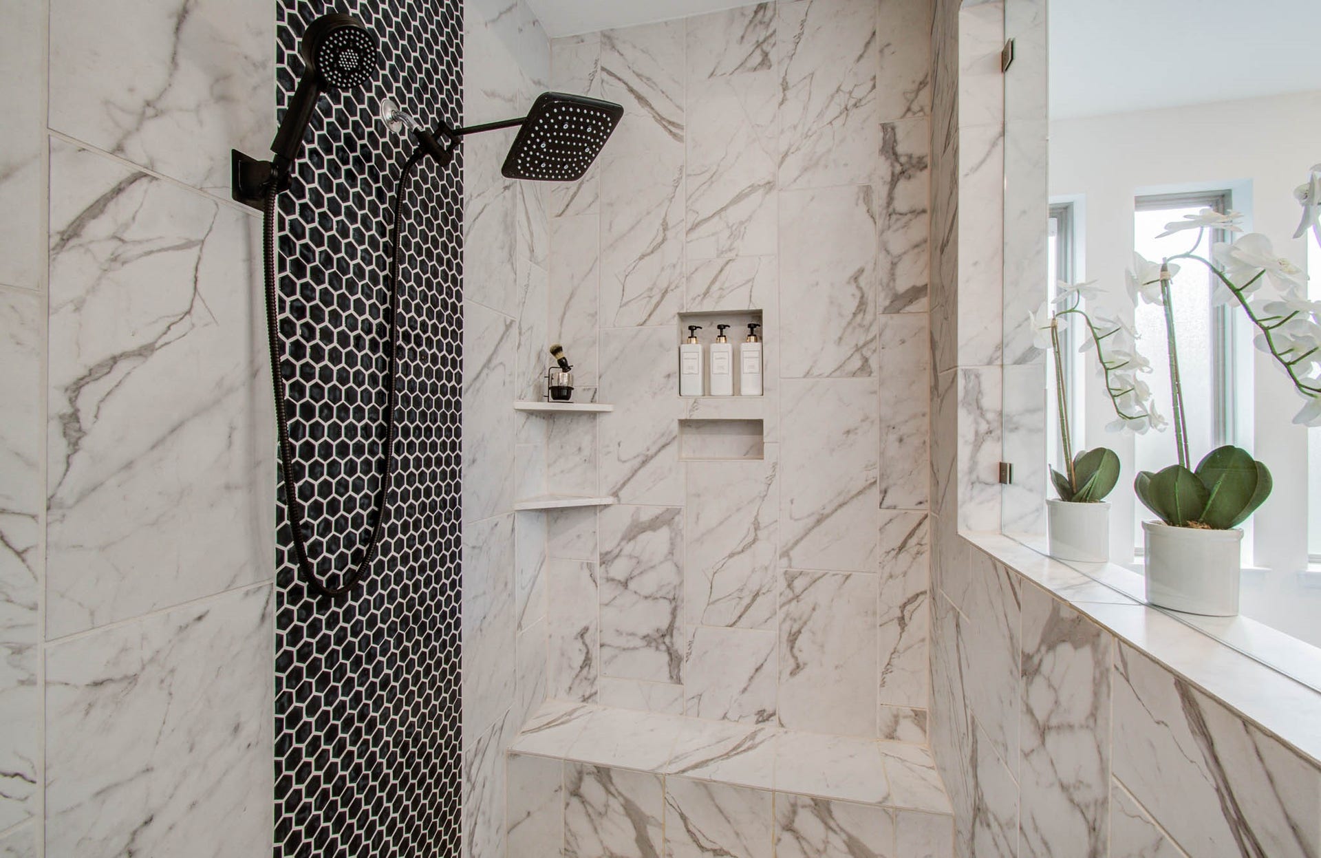 24430 Switchgrass Valley Way, Katy, TX 77493 Experience ultimate luxury in this bright, airy shower featuring elegant marble tiles, a striking black hexagonal accent wall, a modern rain showerhead, and convenient built-in shelving and bench.