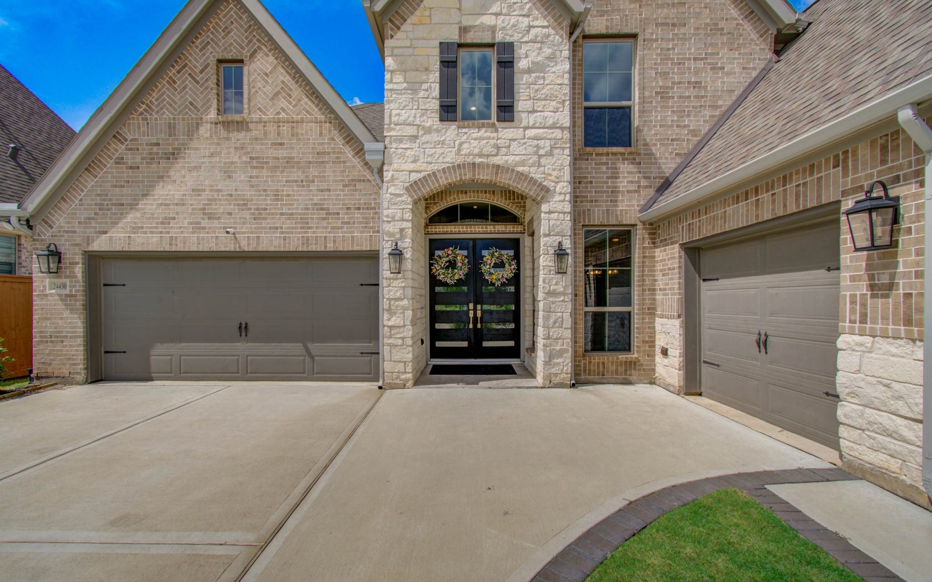 24430 Switchgrass Valley Way, Katy, TX 77493 Discover elegance at 24430 Switchgrass Valley Way, featuring a stunning stone and brick facade with charming double doors and a spacious three-car garage.