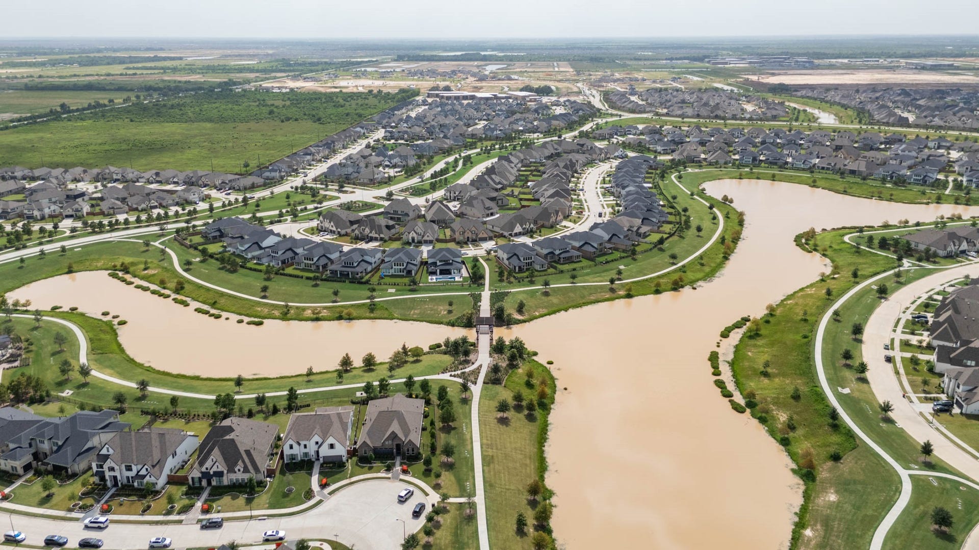 24430 Switchgrass Valley Way, Katy, TX 77493 Experience stunning aerial views of a beautifully designed community with winding streets, lush greenery, and serene waterways, offering a perfect blend of natural beauty and modern living.