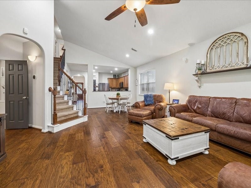 Wood flooring and wrought-iron balusters add character to the open layout.