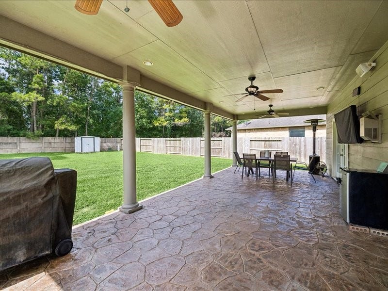 Expansive covered patio with stamped concrete and ceiling fans.
