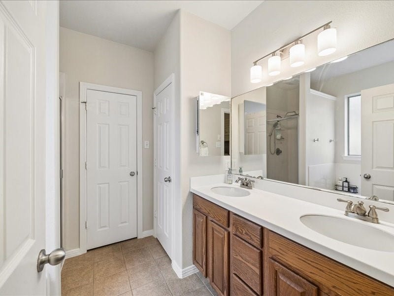 Primary bathroom with dual sinks and generous counter space.
