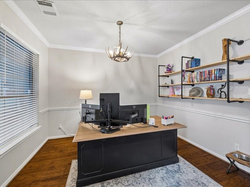 Flexible front room with crown molding and wainscoting, ideal for dining or a home office.