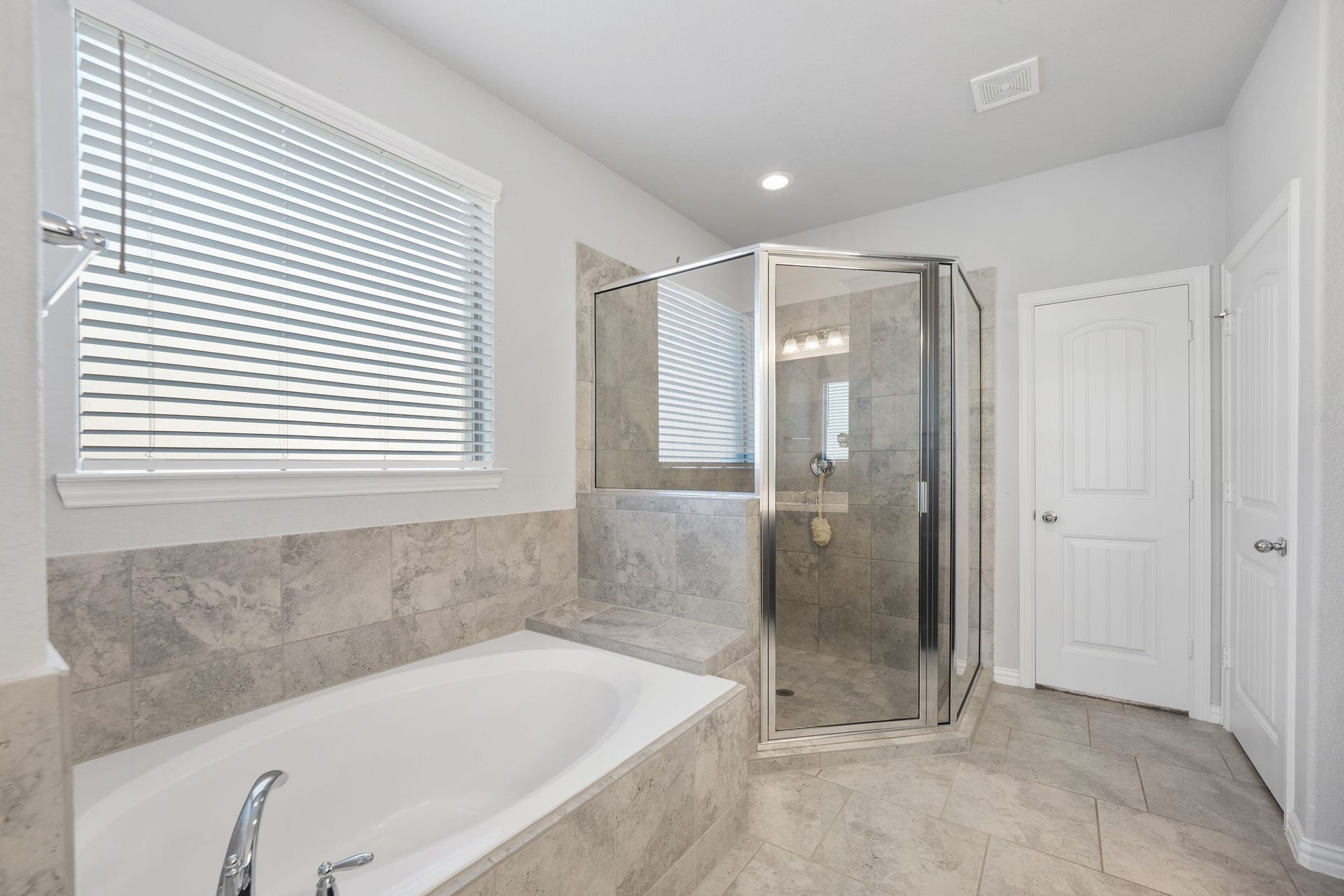 Accessible primary bathroom with garden spa tub with separate shower.