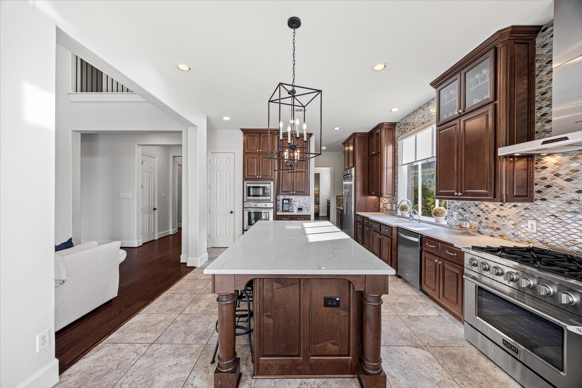 8642 Chickasaw Plum Way, Katy, TX 77494 Gourmet kitchen with oversized island, designer pendant lighting, and rich dark wood cabinetry. New quartz countertops and backsplash (2024). Built-in Thermador fridge.