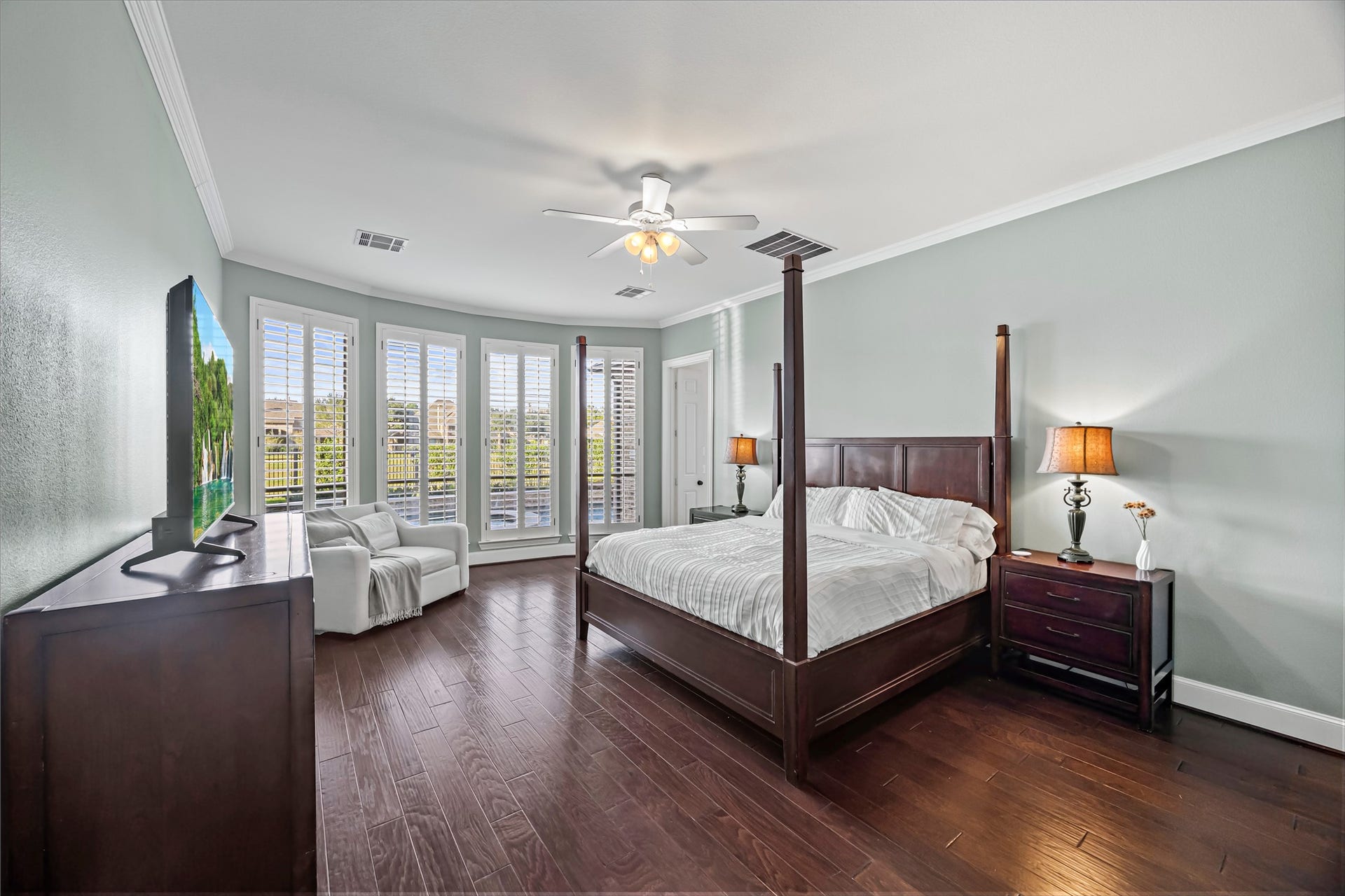 8642 Chickasaw Plum Way, Katy, TX 77494 Spacious primary bedroom with large windows, ceiling fan, and rich dark flooring. New windows (2024). Updated paint throughout.