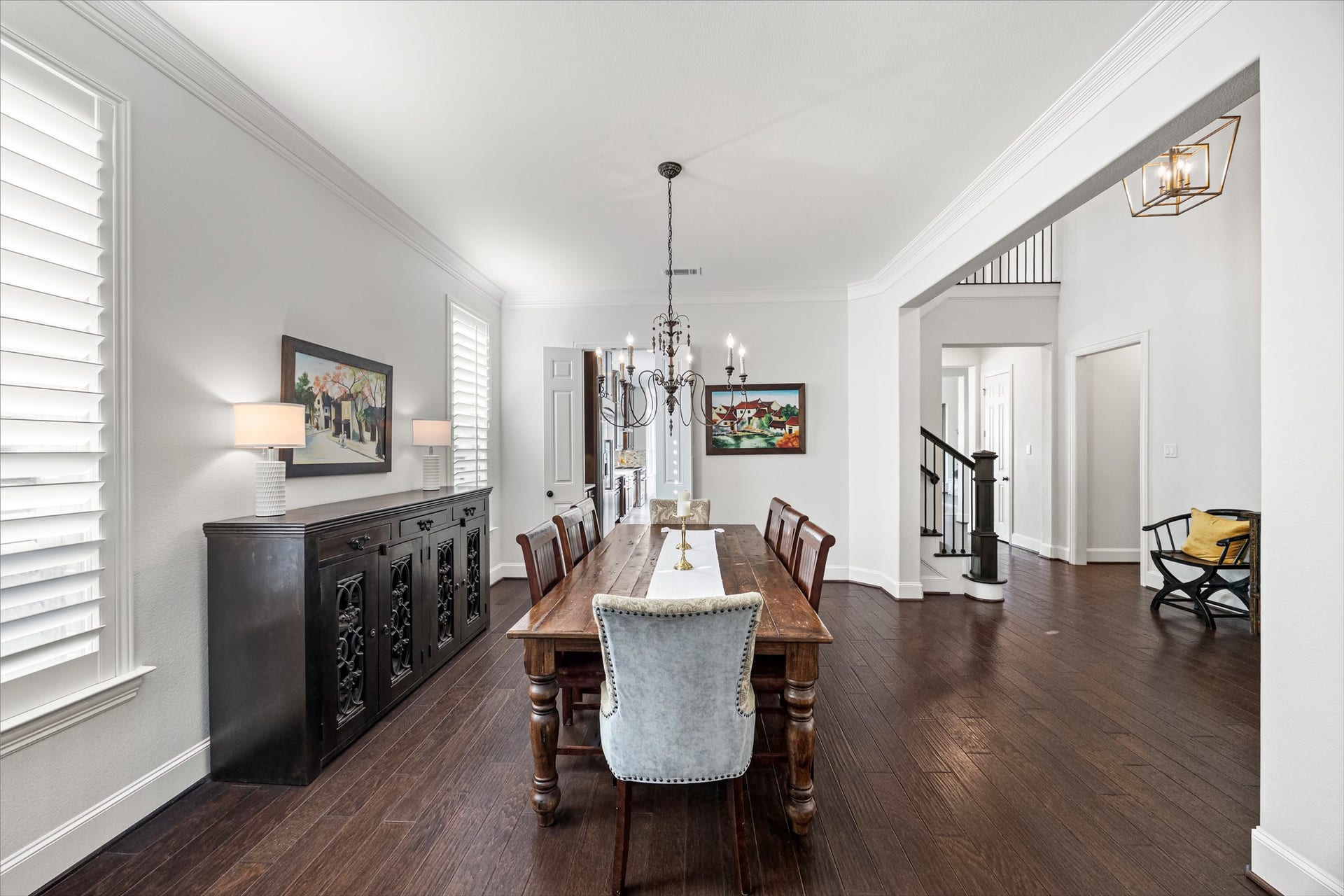 8642 Chickasaw Plum Way, Katy, TX 77494 Formal dining room with designer chandelier, plantation shutters, and room for gatherings of every size. New windows (2024). All new lighting on dimmers.