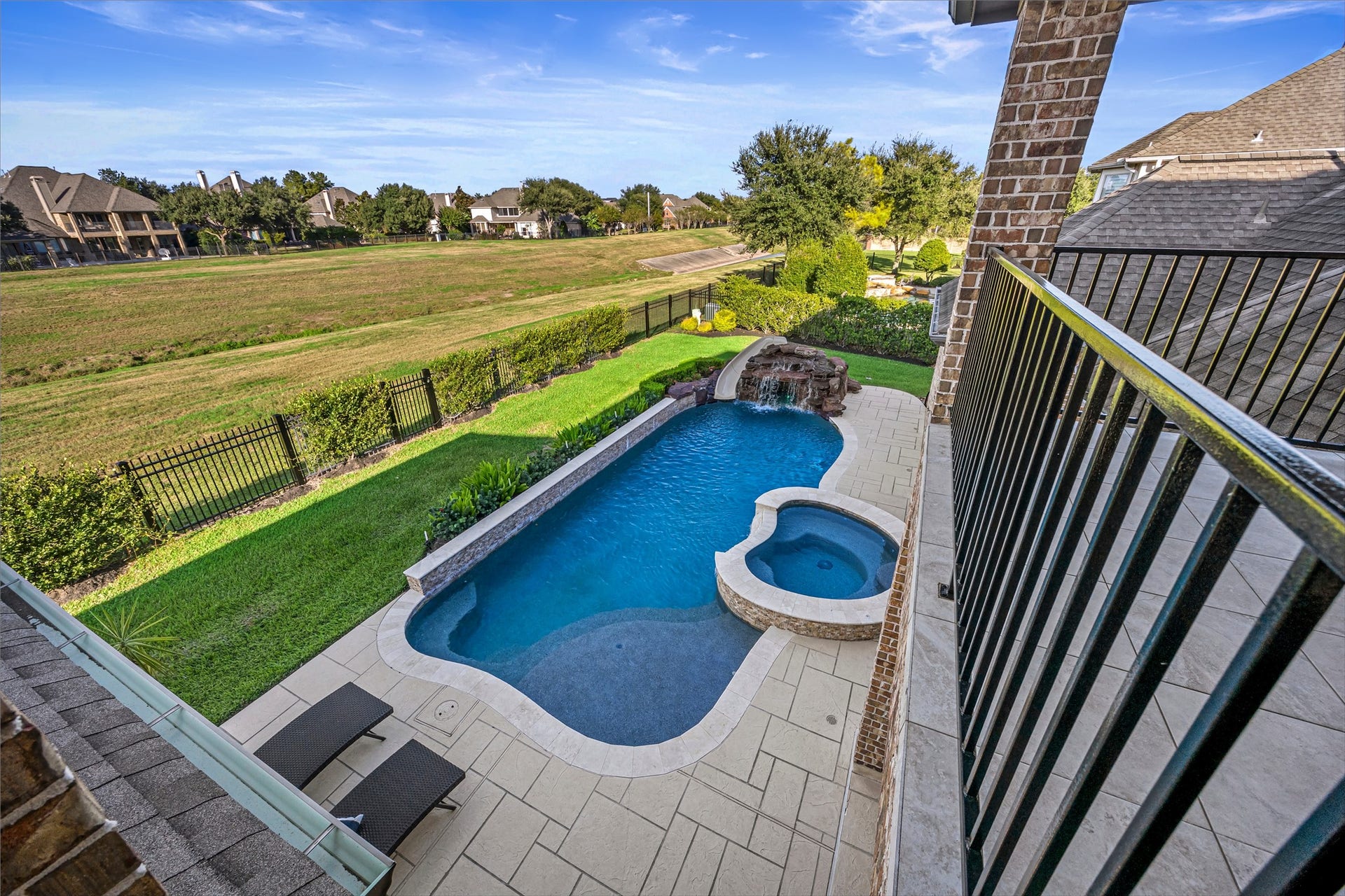 8642 Chickasaw Plum Way, Katy, TX 77494 View from the upper balcony overlooking the pool, with no rear neighbors and a greenspace behind the home. Golf course views to the west.