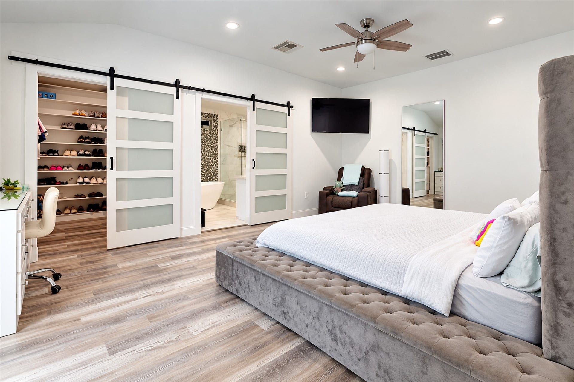 827 Dondell Street, Channelview, TX 77530 827 Dondell, Spacious primary suite, wooden laminate flooring throughout, recessed lighting, modern cieling fan, frosted glass panel walk-in closet and bathroom farm doors and built in vanity.