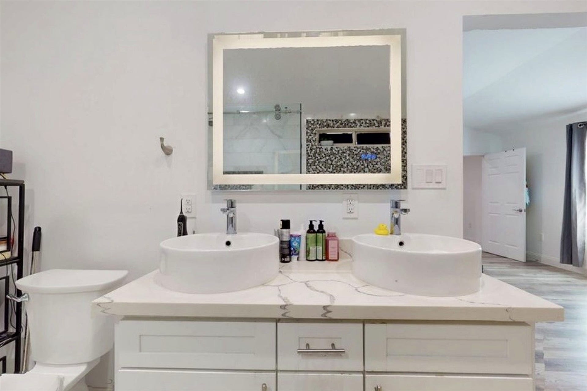827 Dondell Street, Channelview, TX 77530 827 Dondell, Primary bathroom with double vessel sinks and white vanity and modern illustrated mirror.