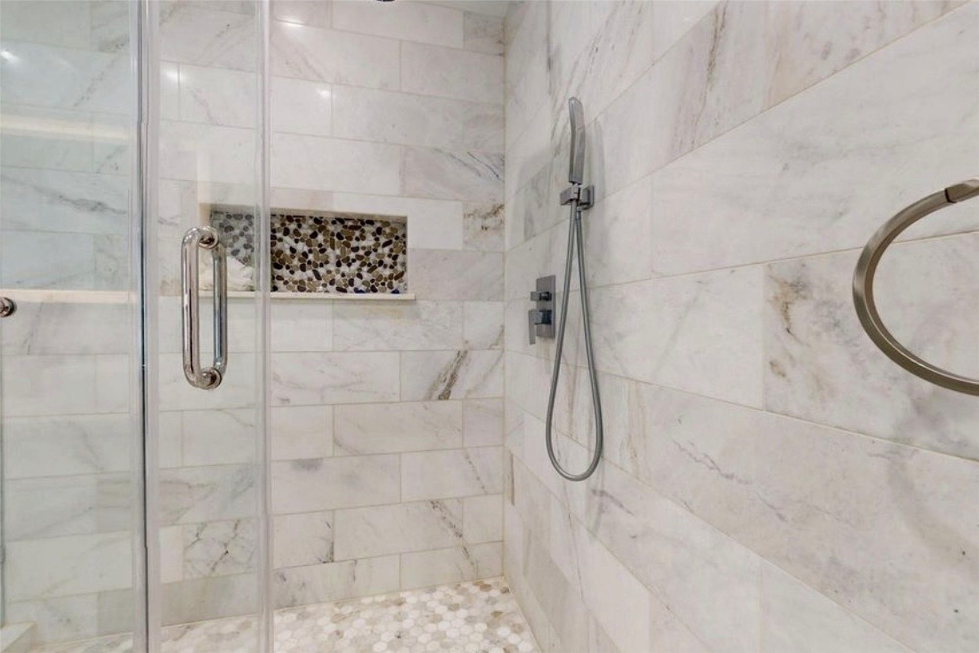 827 Dondell Street, Channelview, TX 77530 827 Dondell, Primary bedroom, with marble tile and a pebble mosaic built in niche and a handheld shower head with flexible hose.