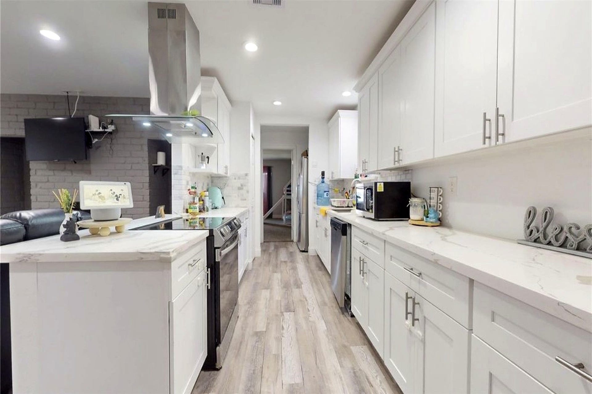 827 Dondell Street, Channelview, TX 77530 827 Dondell, Large kitchen with tall white cabinetry wooden laminate flooring, recessed lighting, modern hardware, stainless steel appliances and quartz countertops