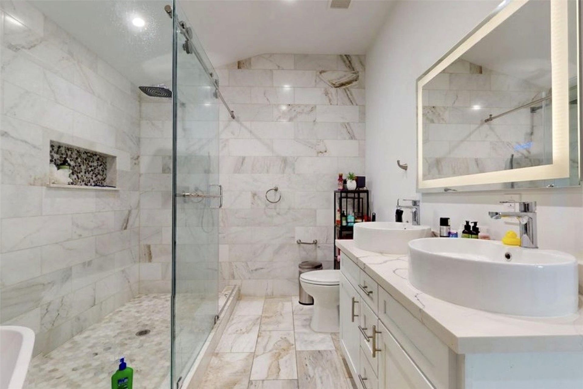 827 Dondell Street, Channelview, TX 77530 827 Dondell, Primary bathroom, with marble walls and flooring, staning shower, white double vessel sinks vanity and modern illuminated mirror fixtures.