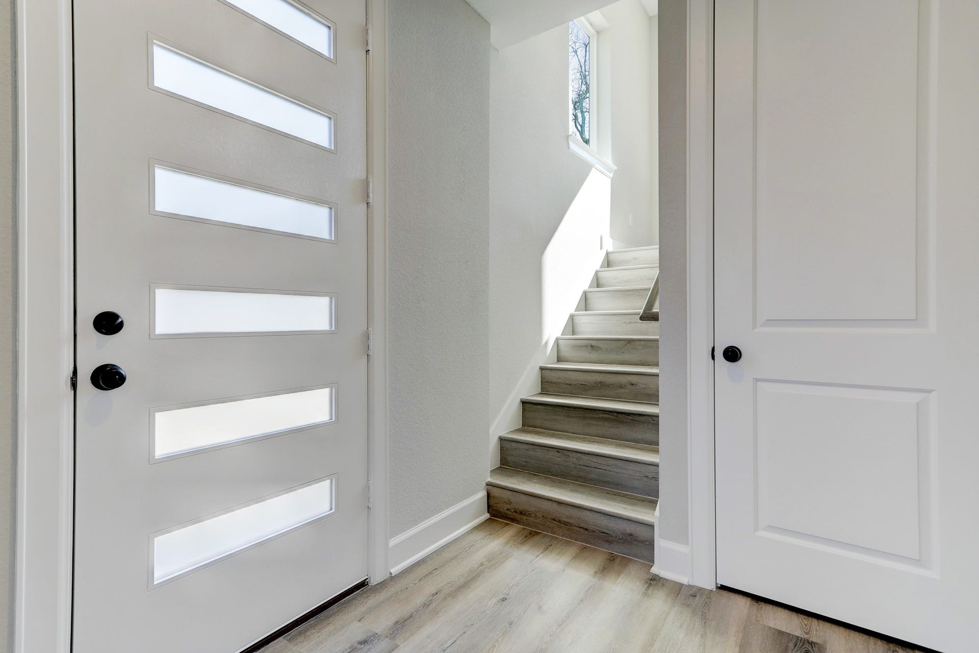 Welcoming entry with a modern front door, contemporary finishes, and convenient storage.