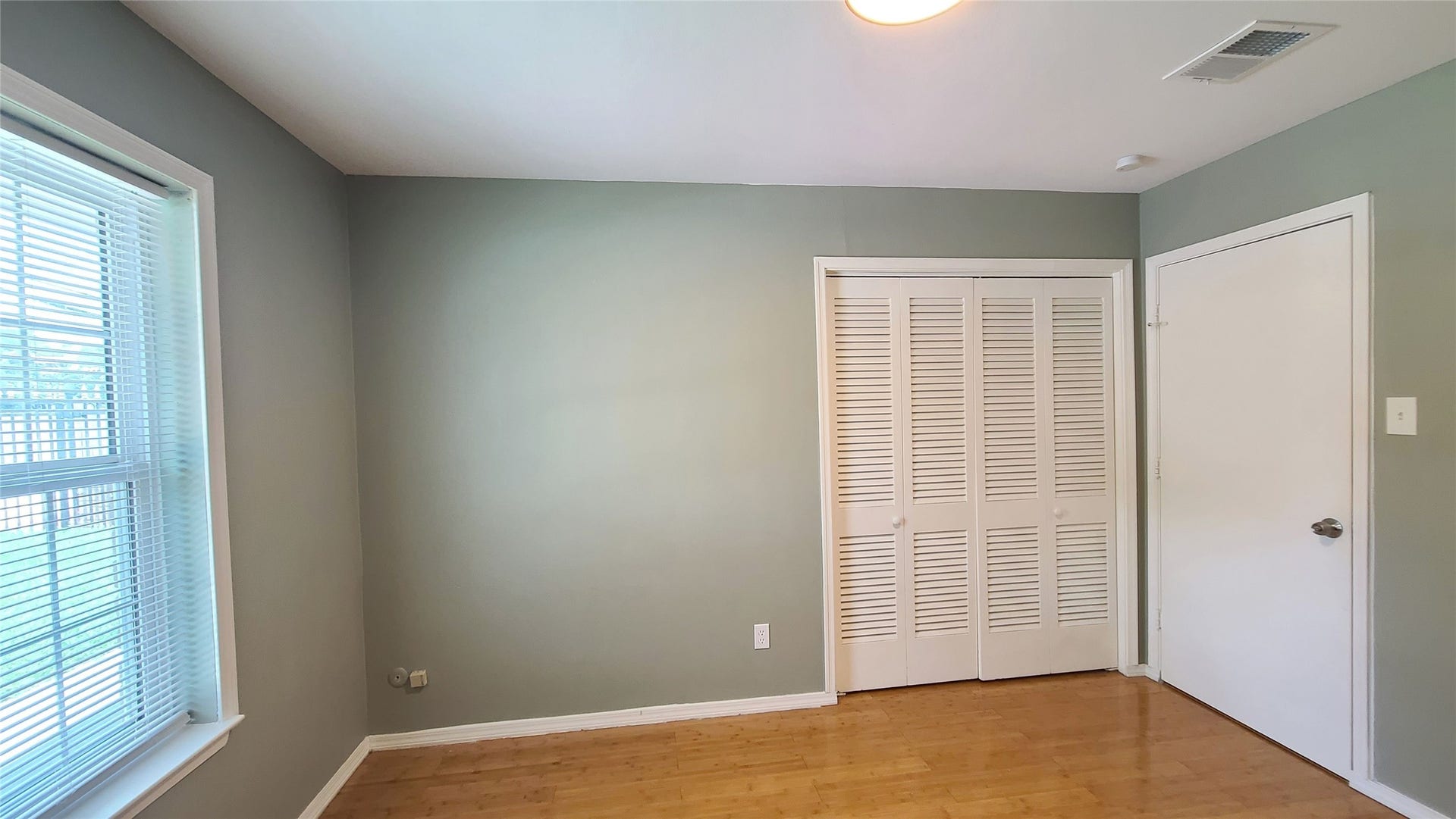 902 Ashford Parkway, Houston, TX 77077 Bask in the serene ambiance of this bright bedroom, where natural sunlight streams through the window, highlighting elegant furnishings and creating a warm, inviting sanctuary.