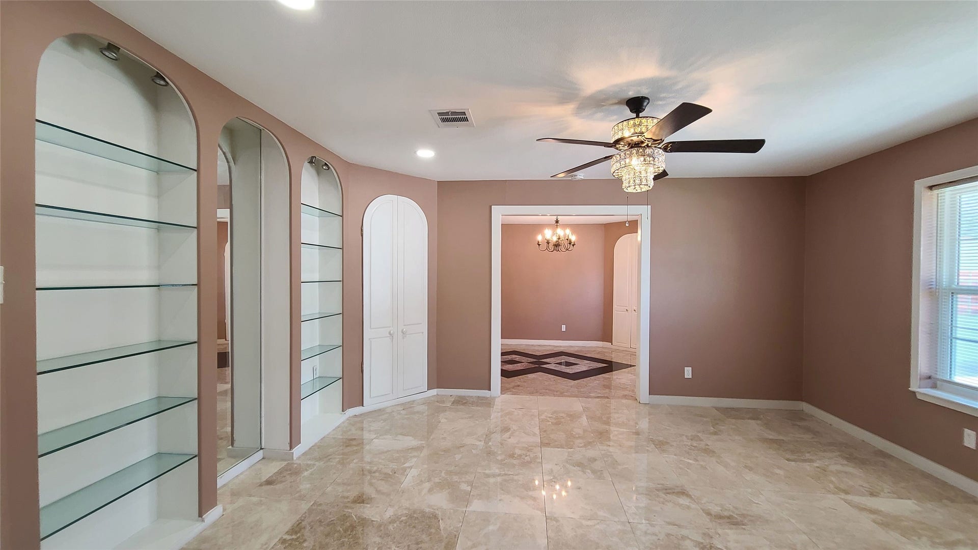 902 Ashford Parkway, Houston, TX 77077 The formal living room boasts elegant fan lighting and two sleek glass shelves, creating a sophisticated ambiance.