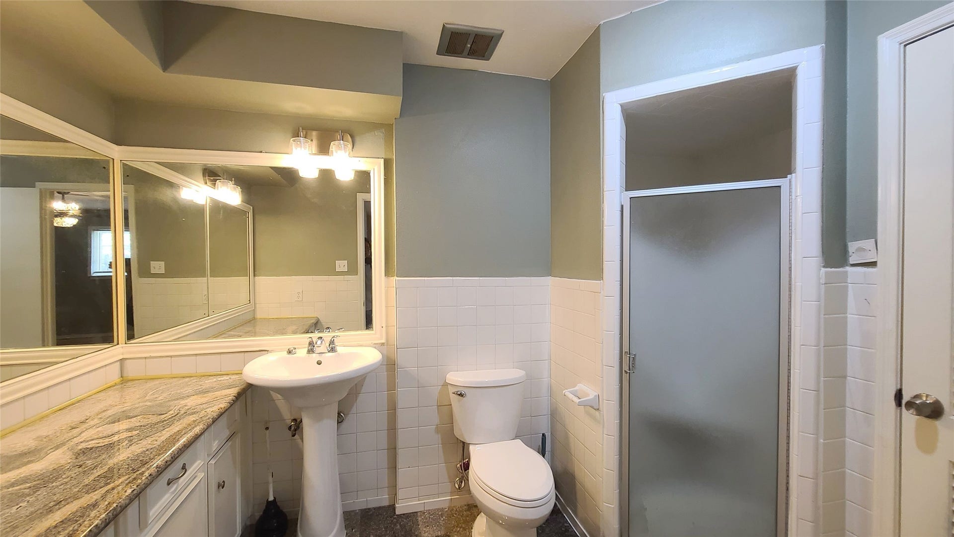 902 Ashford Parkway, Houston, TX 77077 Step into the inviting primary bath featuring a sleek granite countertop and a spacious walk-in shower, perfect for unwinding in style.